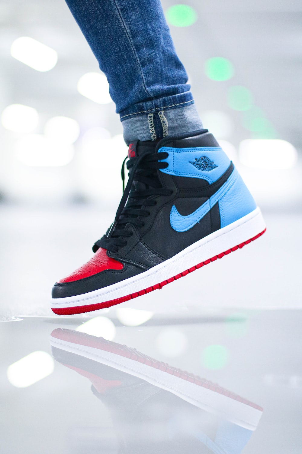 Person wearing black blue and white nike air jordan 1 shoes photo
