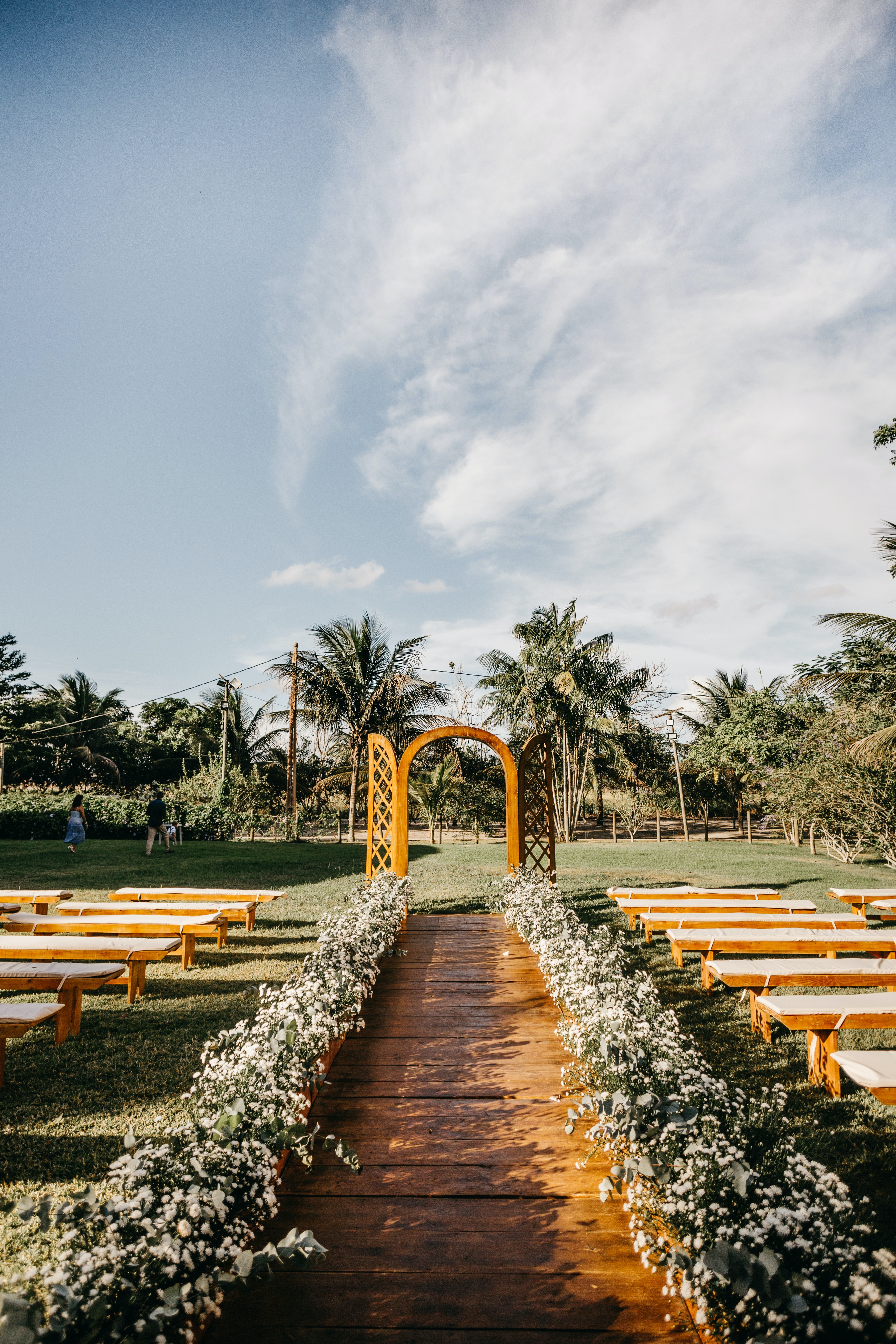 Wedding arch and benches arranged in lush park · Free