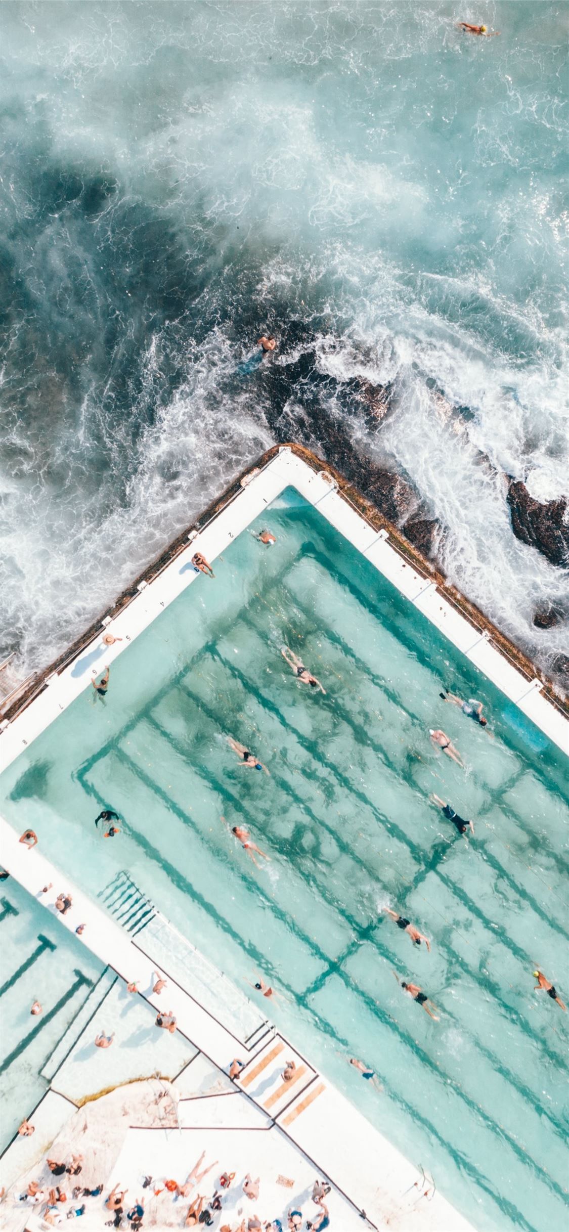 pool with people swimming nearby seashore iPhone 11 Wallpaper in 2023