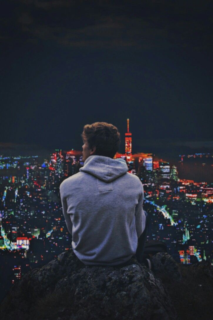 Man Enjoying City Lights from Rock