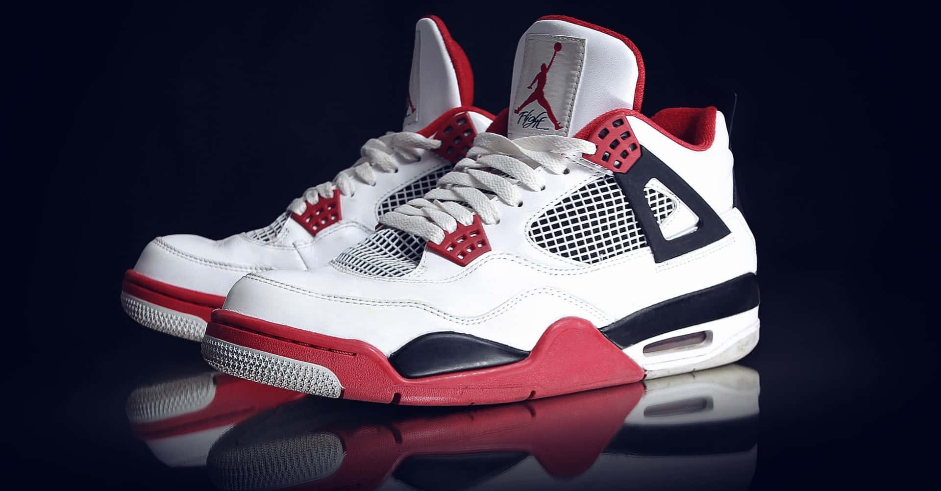Download A Pair Of White And Red Air Jordan 4 Sneakers Wallpaper