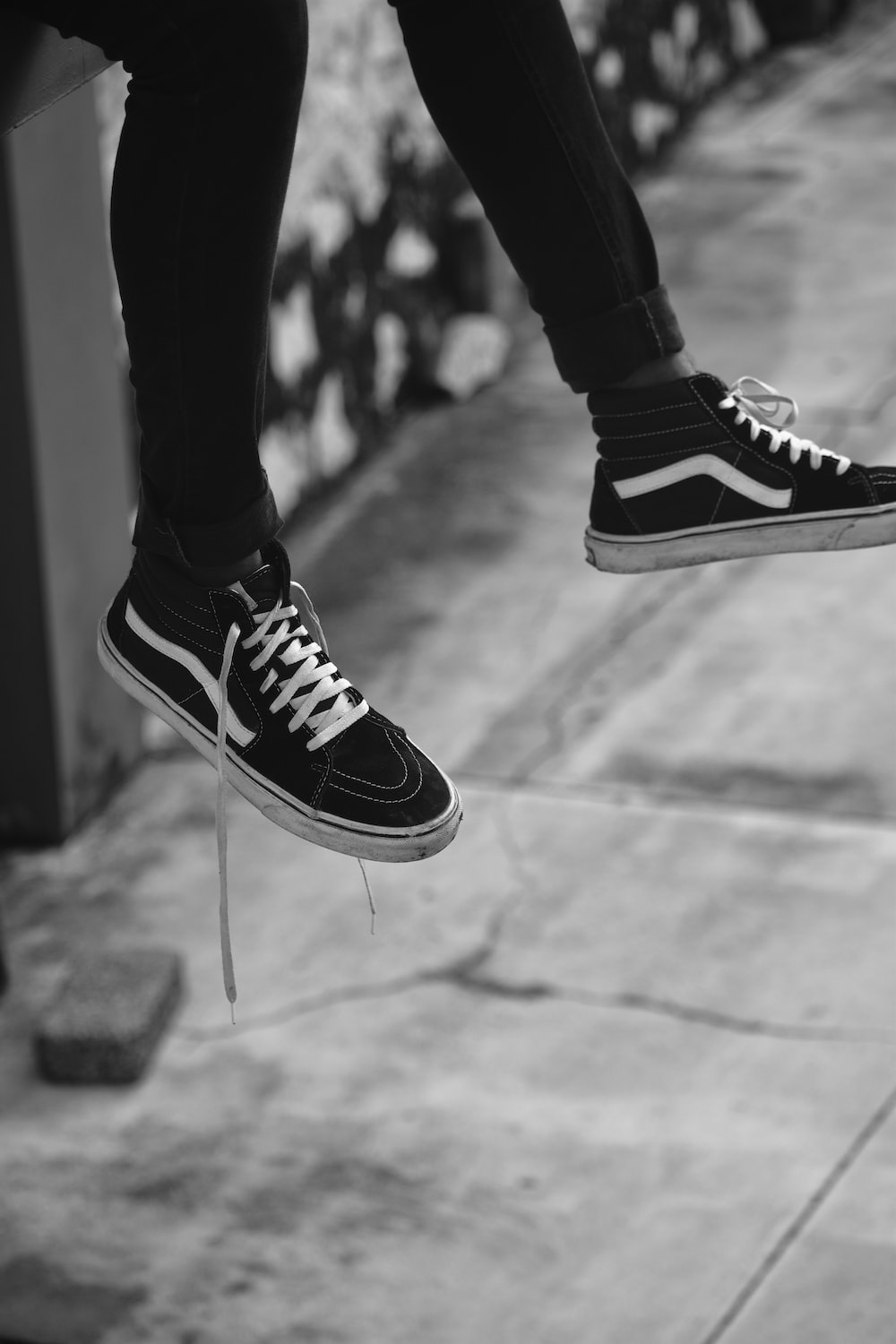 Person wearing black and white vans low top sneakers photo