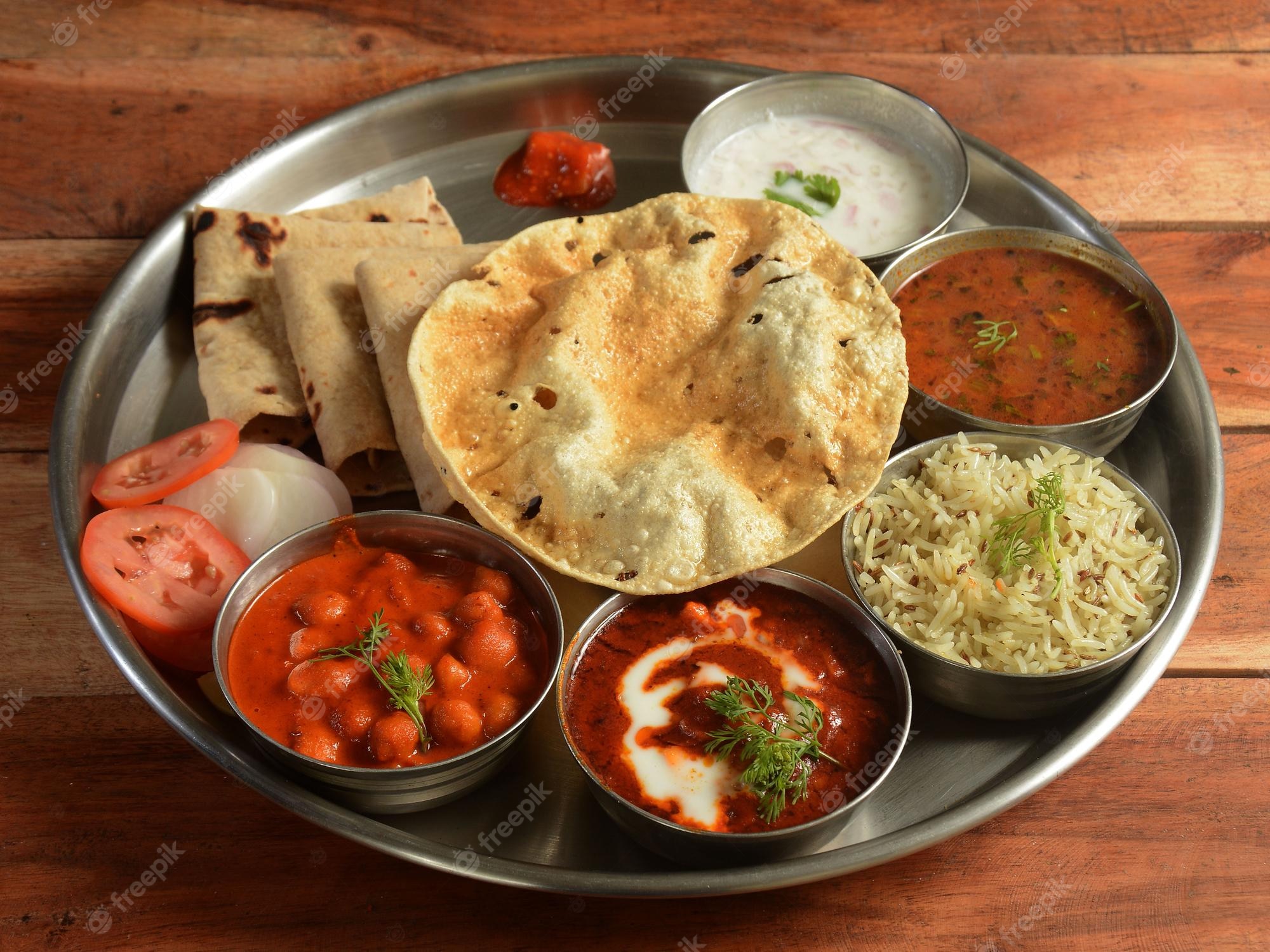 Premium Photo. Punjabi veg thali from an indian cuisine food platter consists variety of veggies lentils jeera rice roti sweet dish curd pickle etc selective focus