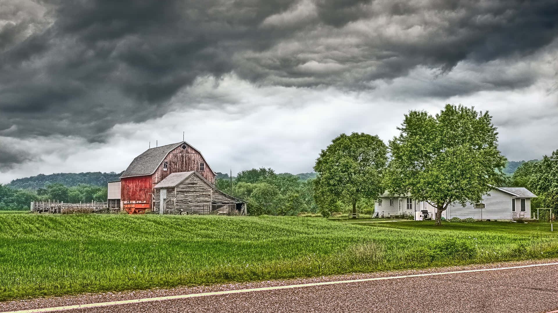 Download A Red Barn And A Farm Under A Stormy Sky Wallpaper