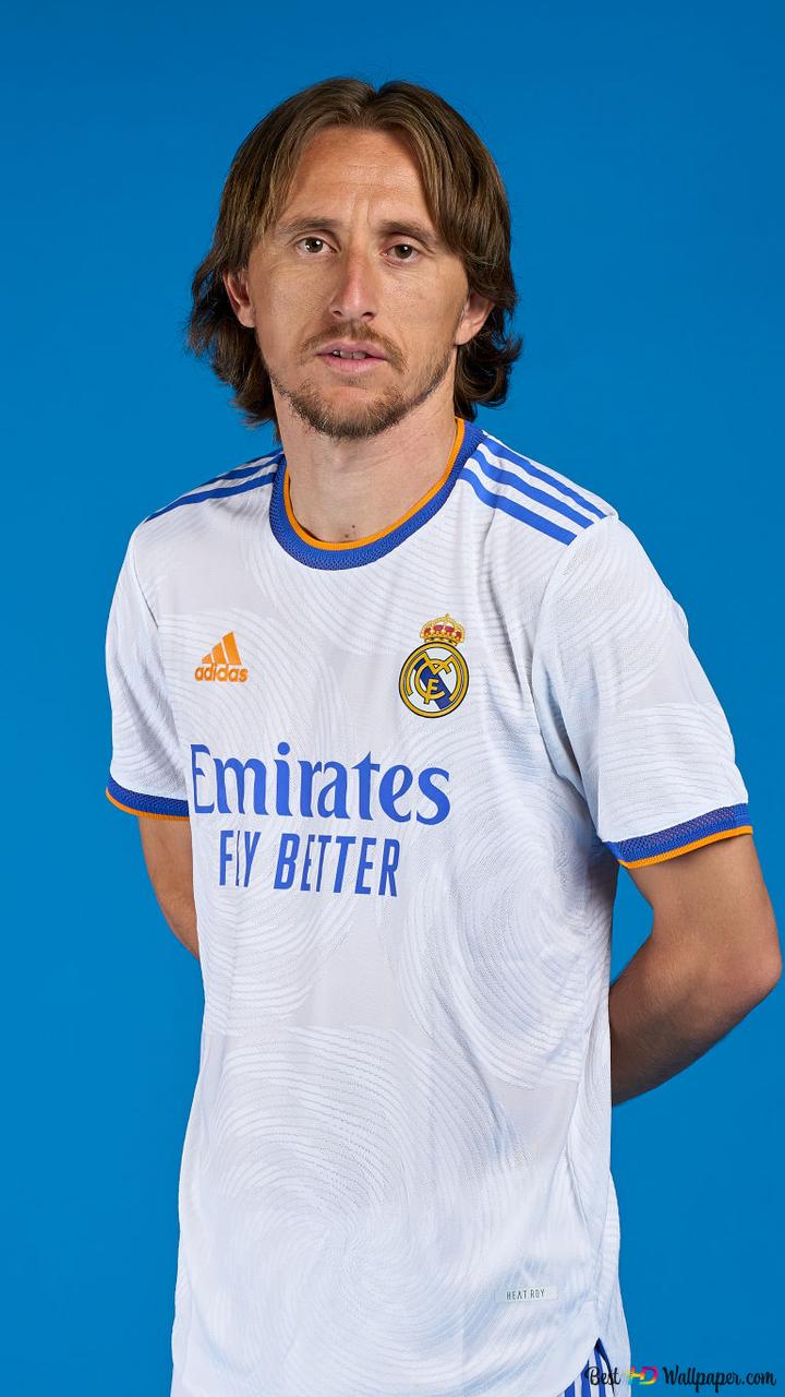 Luka Modric, Real Madrid's Croatian national football player, poses with his hands behind his back in front of a blue background 2K wallpaper download