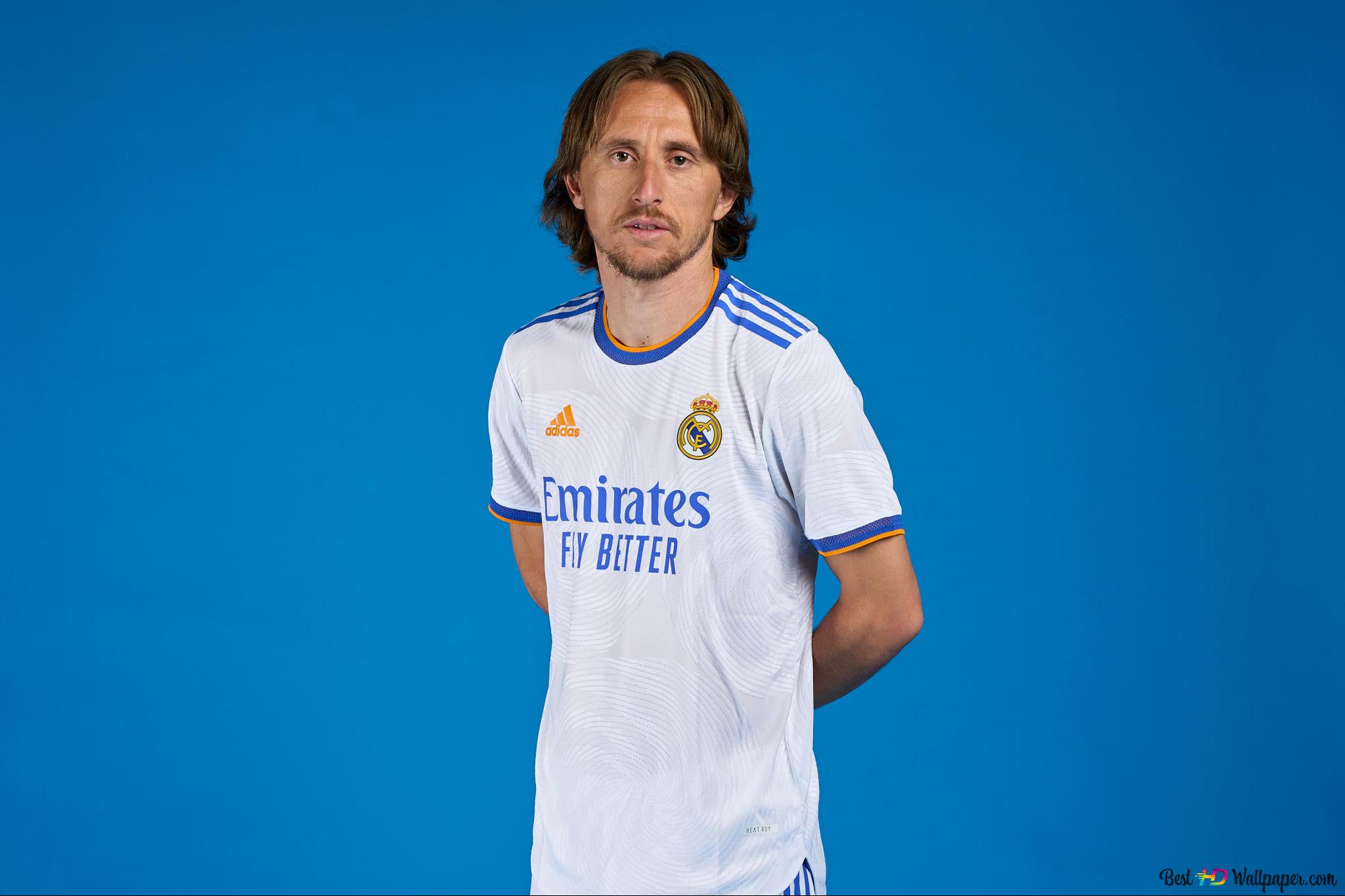 Luka Modric, Real Madrid's Croatian national football player, poses with his hands behind his back in front of a blue background 2K wallpaper download