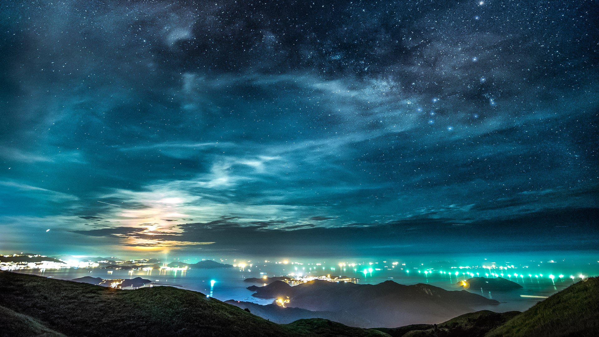 Dramatic summer night sky with the Moon over Hong Kong cityscape. Windows 10 Spotlight Image