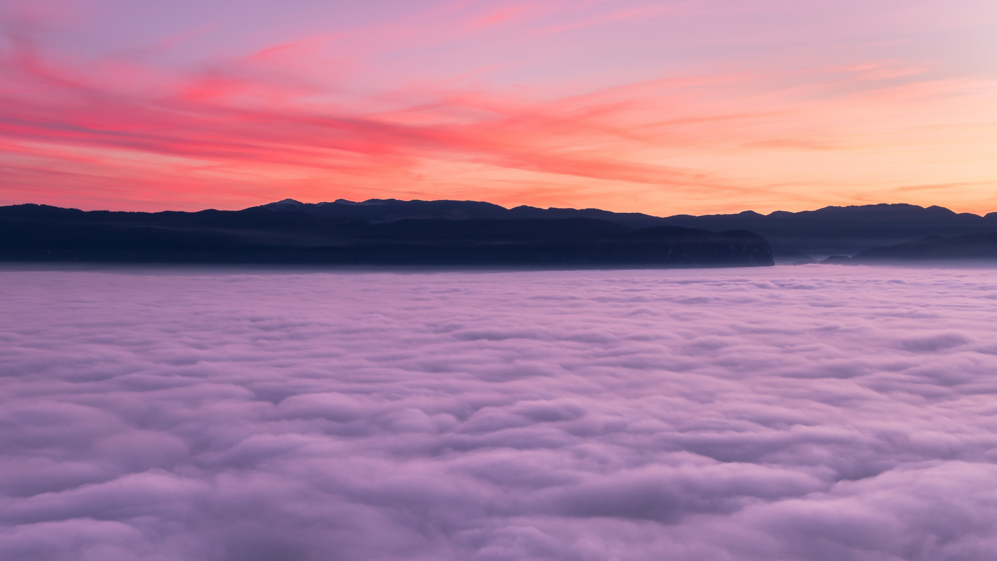 Wallpaper / the pink and purple sky during sunrise or sunset over the clouds and mountains in ajdna, foggy sunset 4k wallpaper free download