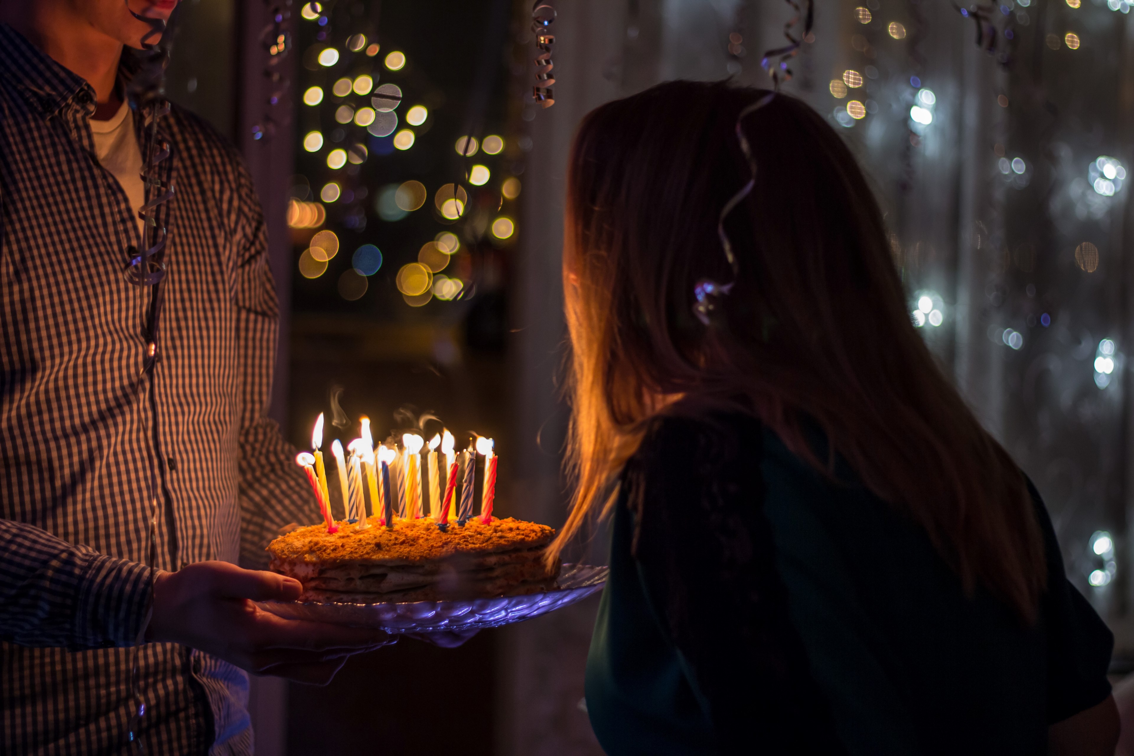 Wallpaper / a man bringing a birthday cake with candles to a woman in a room filled with balloons, happy birthday 4k wallpaper free download