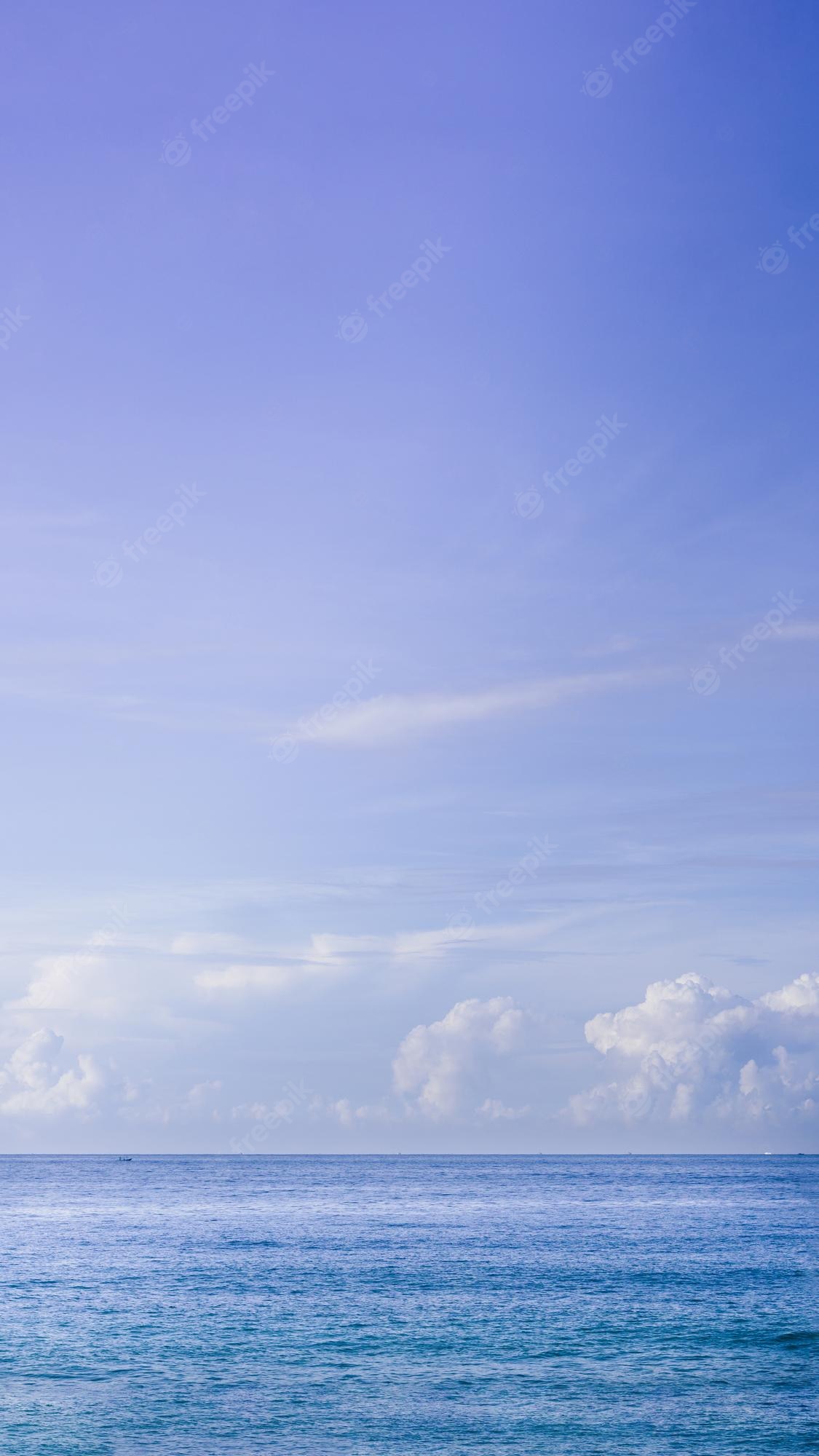 Premium Photo. Vertical atmosphere panorama real photo beautiful summer white cloud clear blue purple tone sky horizon line calm sea concept paradise life design relax wallpaper background more format in stock