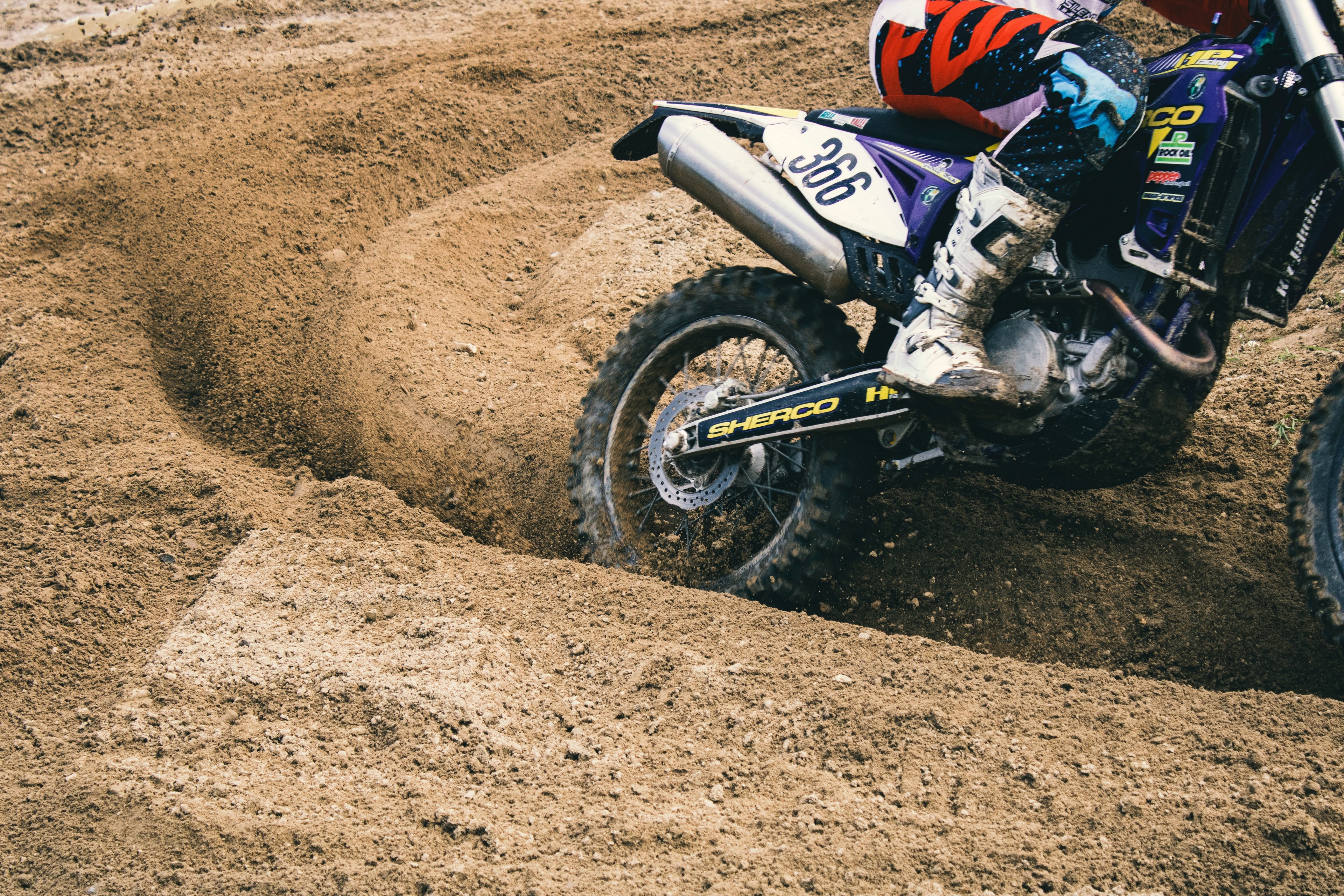 Wallpaper / person in boots on a dirt bike on dirt track speeding on track, dirt bike on dirt track 4k wallpaper free download