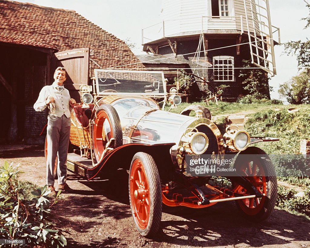Dick Van Dyke posing beside the car
