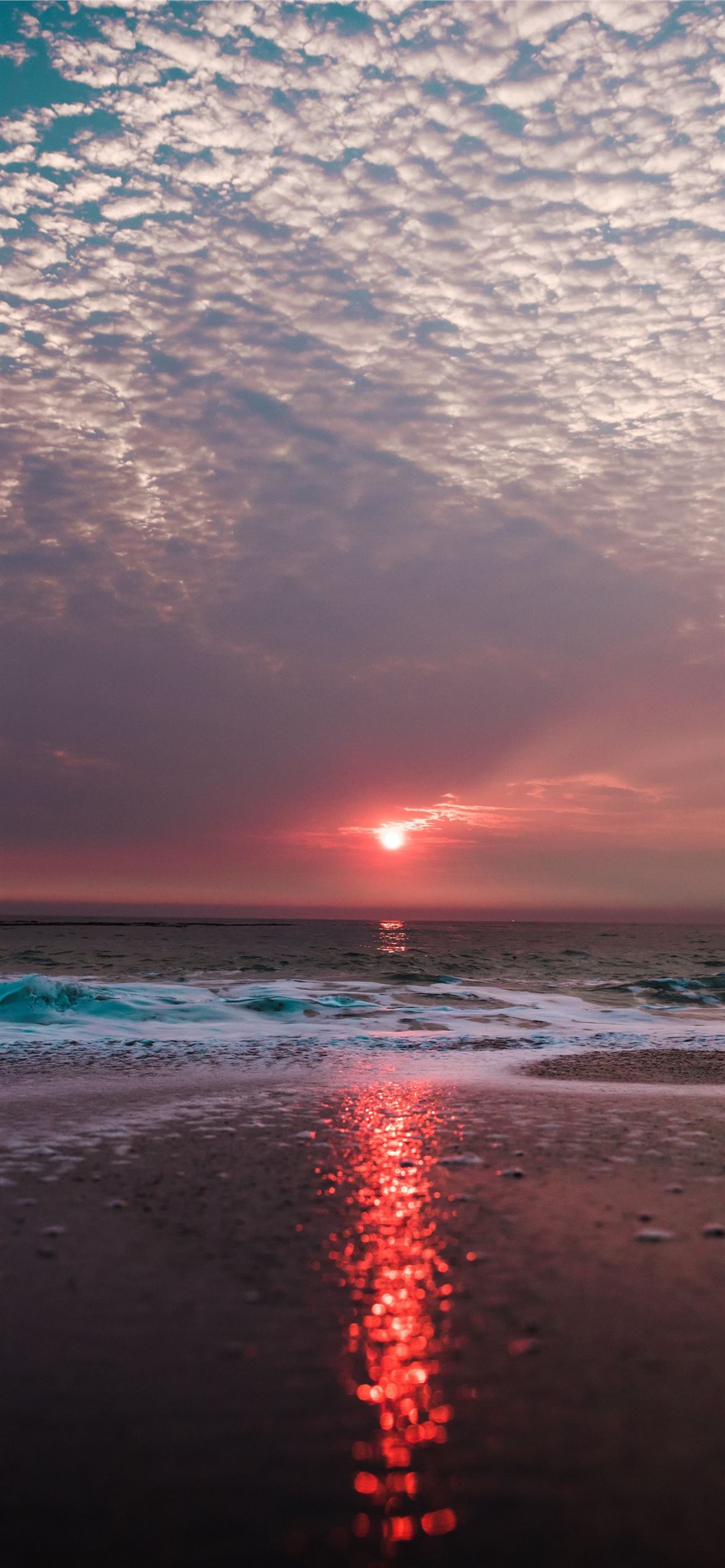 beach under cloudy sky during sunset