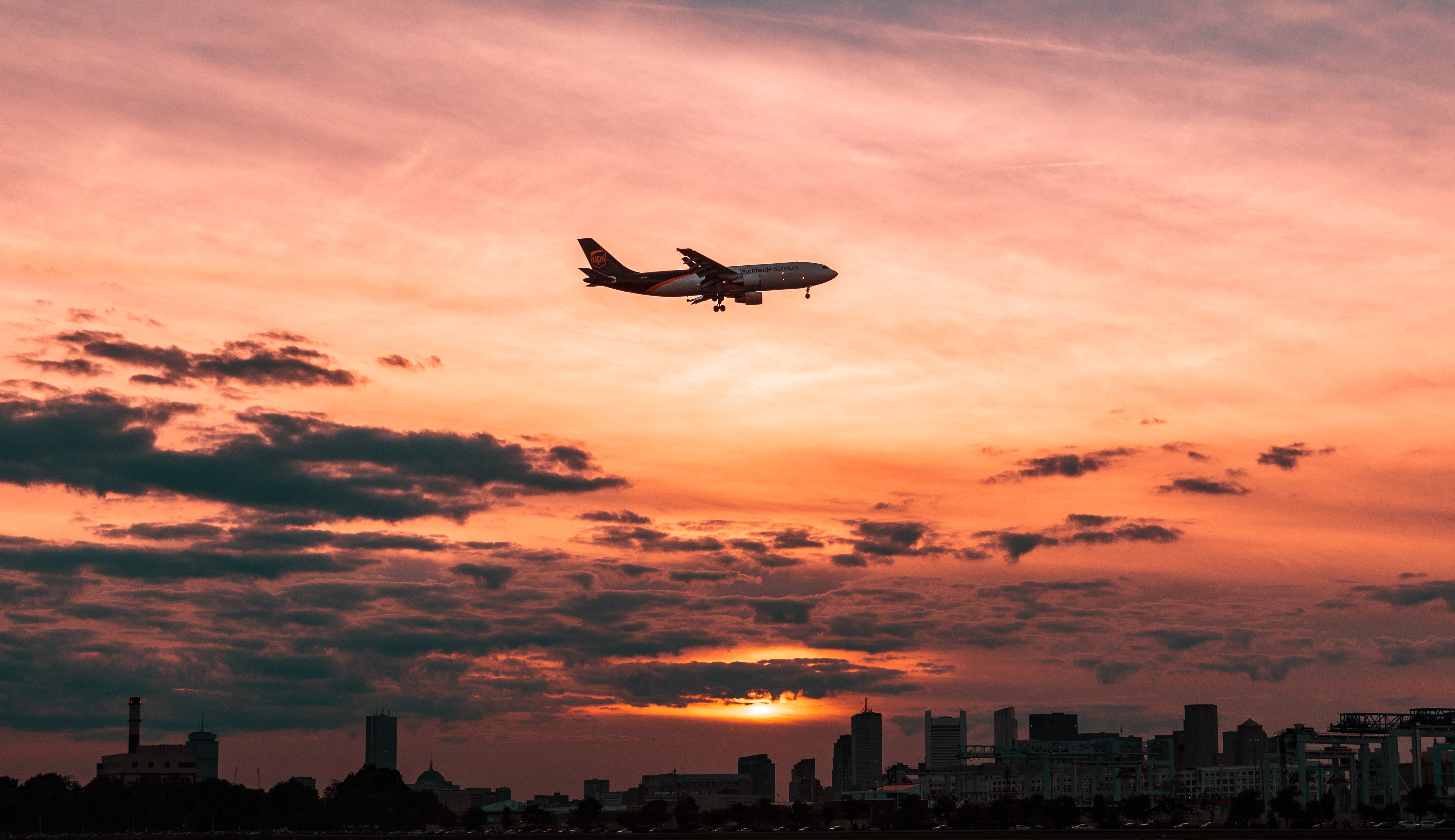 Wallpaper White Airplane Flying Over The City During Sunset, Background Free Image
