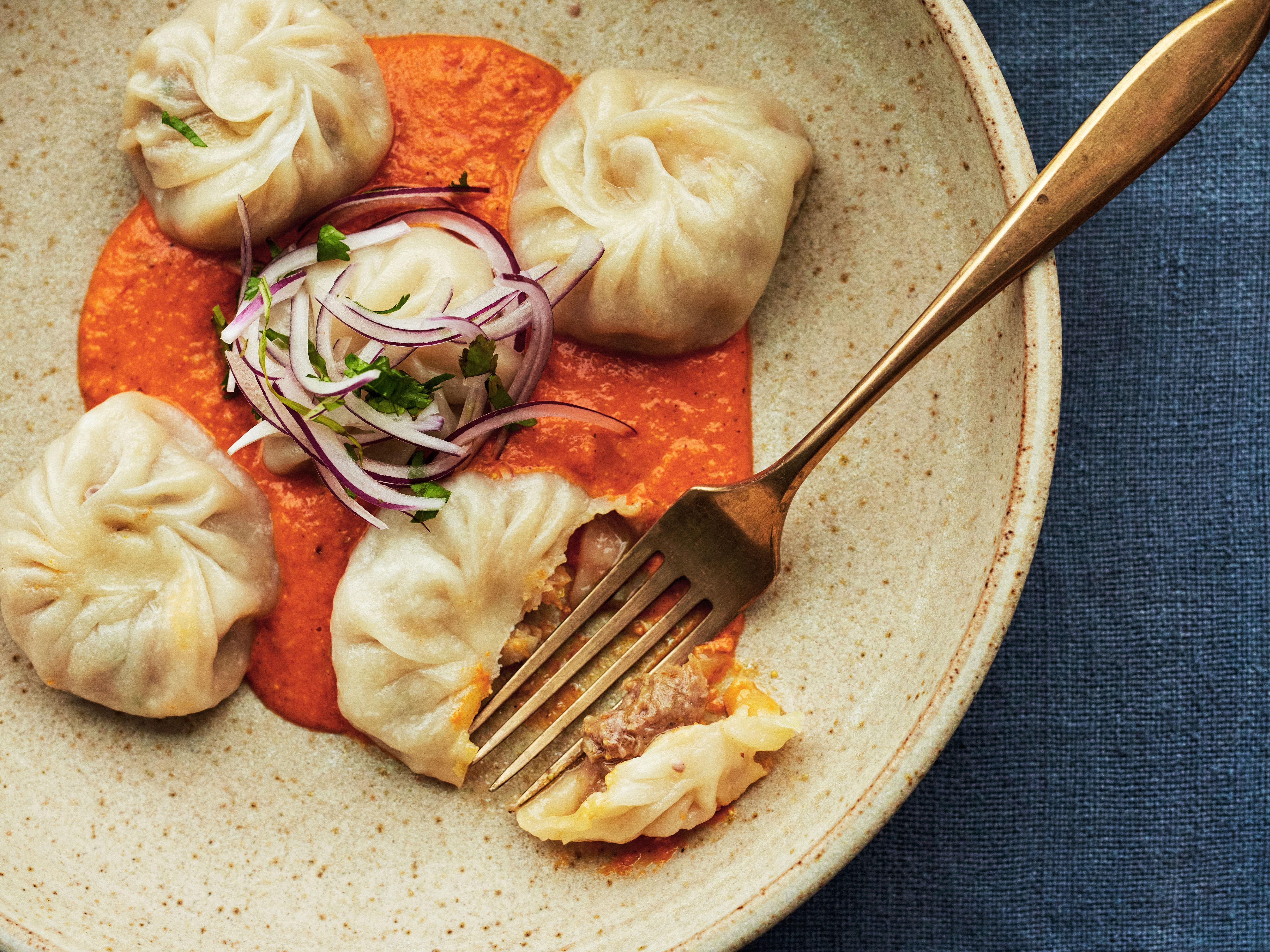 Steamed chicken momos (kukhura ko momo) with ginger, chilli and tomato sesame chutney. House & Garden