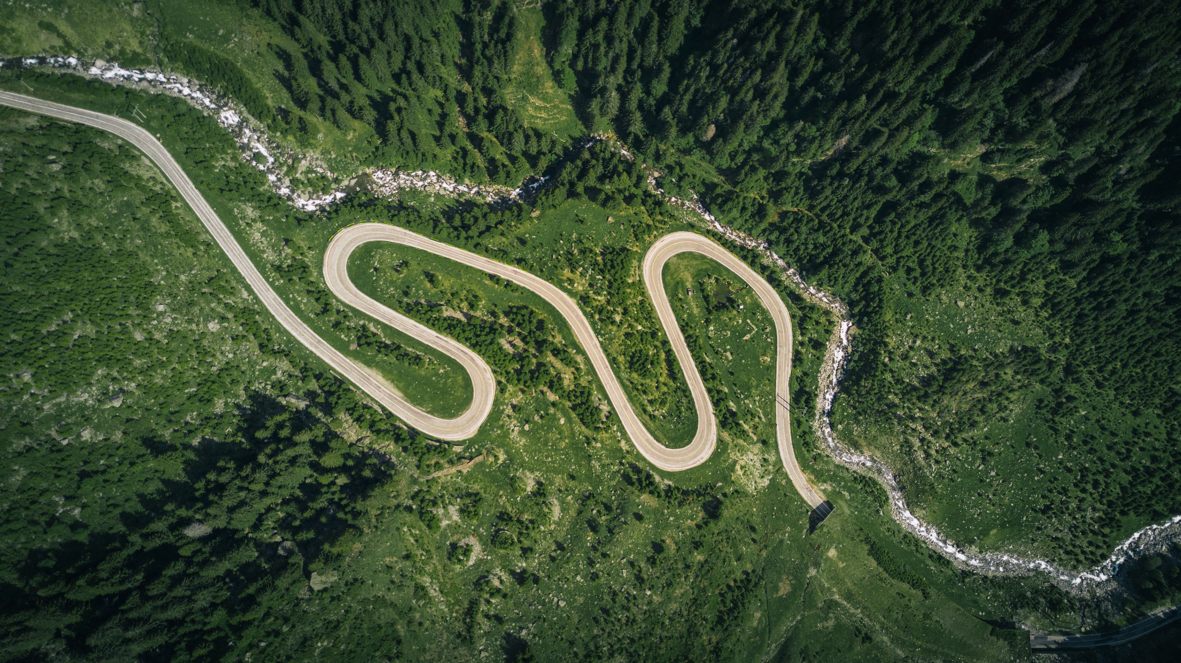 Wallpaper / a drone shot of a zigzagging road leading into a tunnel, transfagarasan by drone 4k wallpaper free download