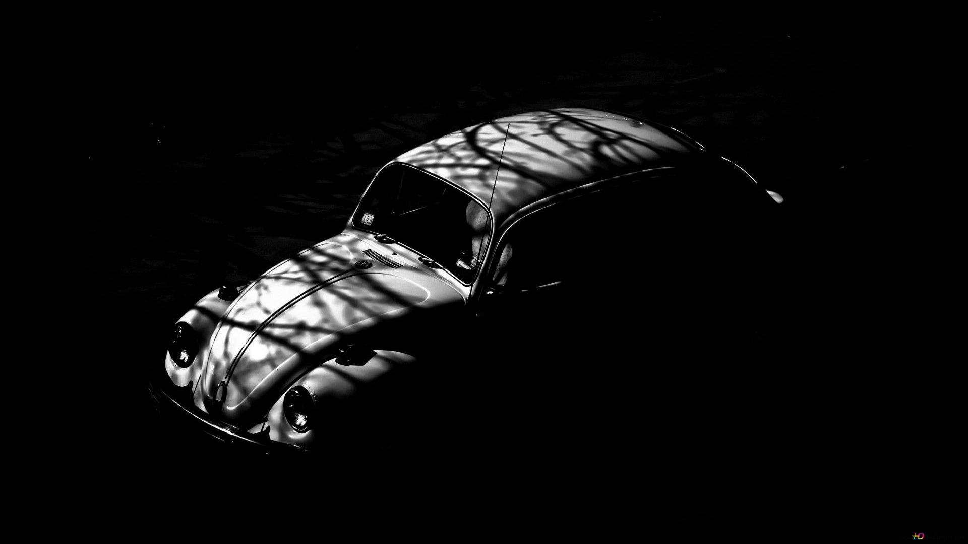 A vintage car with white lights and shadows forming shapes on a black background HD wallpaper download