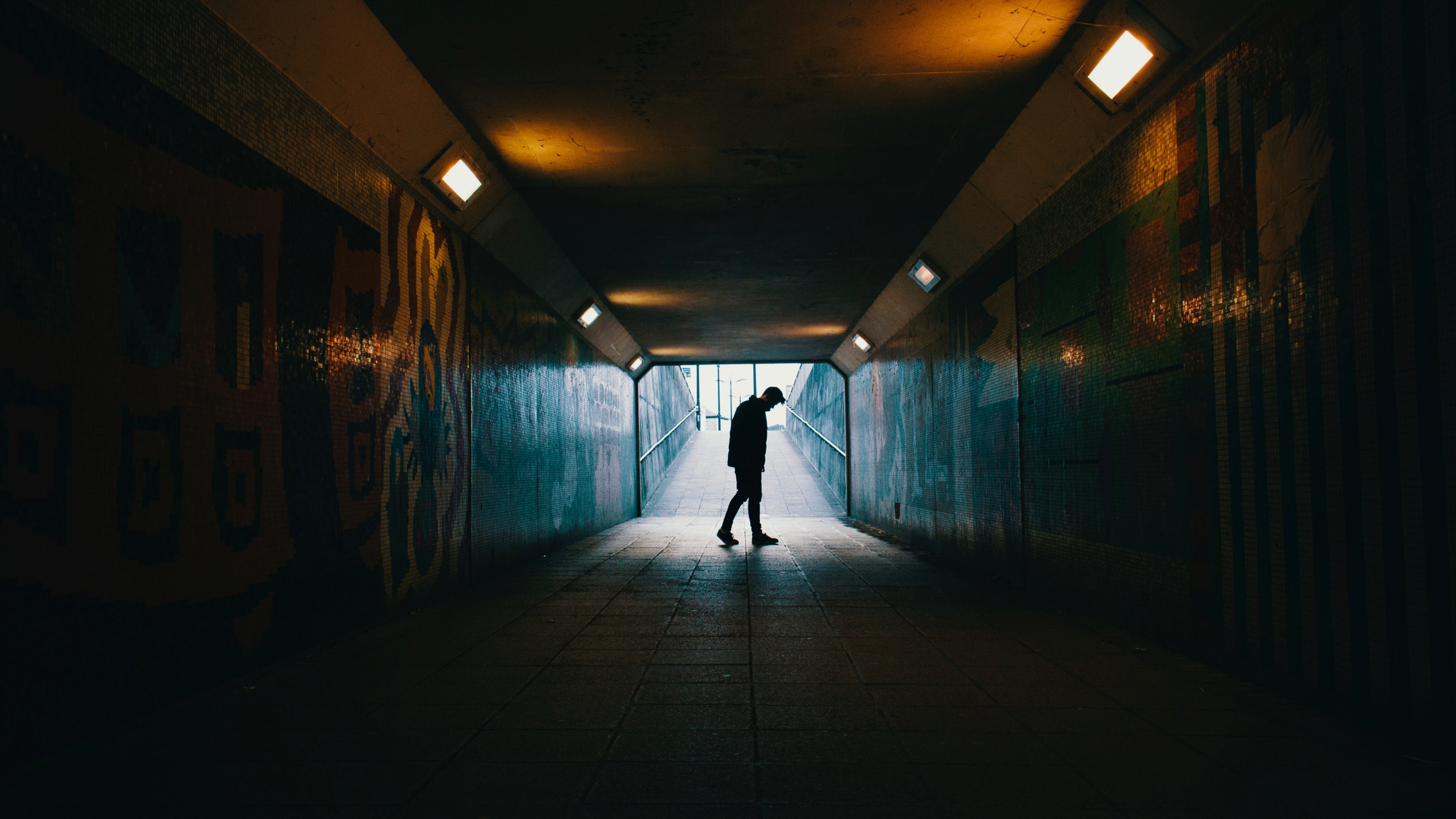 Wallpaper / silhouette of sad person walking through an urban tunnel, lonely and alone 4k wallpaper free download