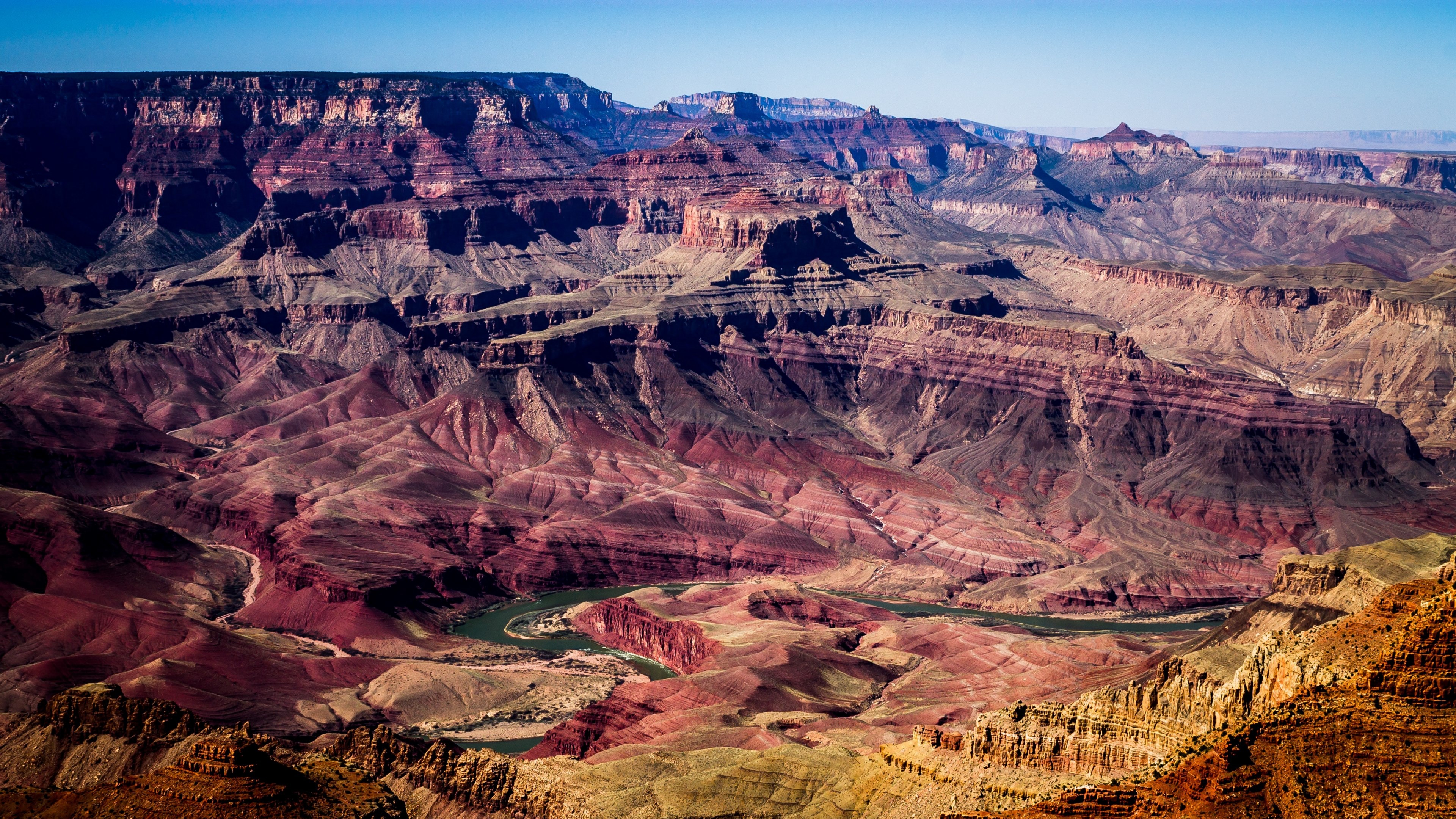 Wallpaper / grand canyon aerial shot showing the ravine and layers of red and orange rocks, colorful grand canyon 4k wallpaper free download