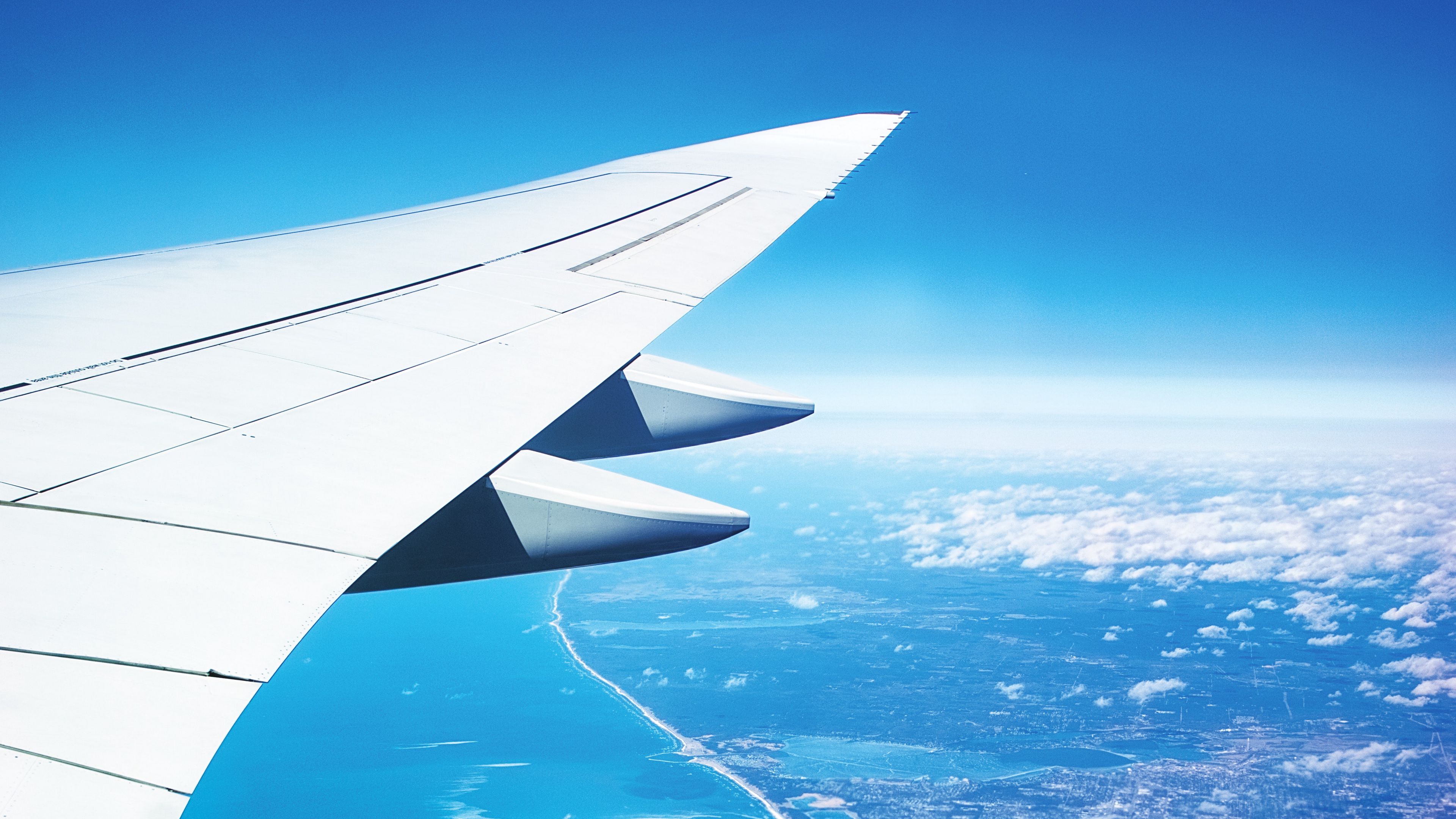 Wallpaper / wing, plane, view from above, city, flight, ocean, 4k free download