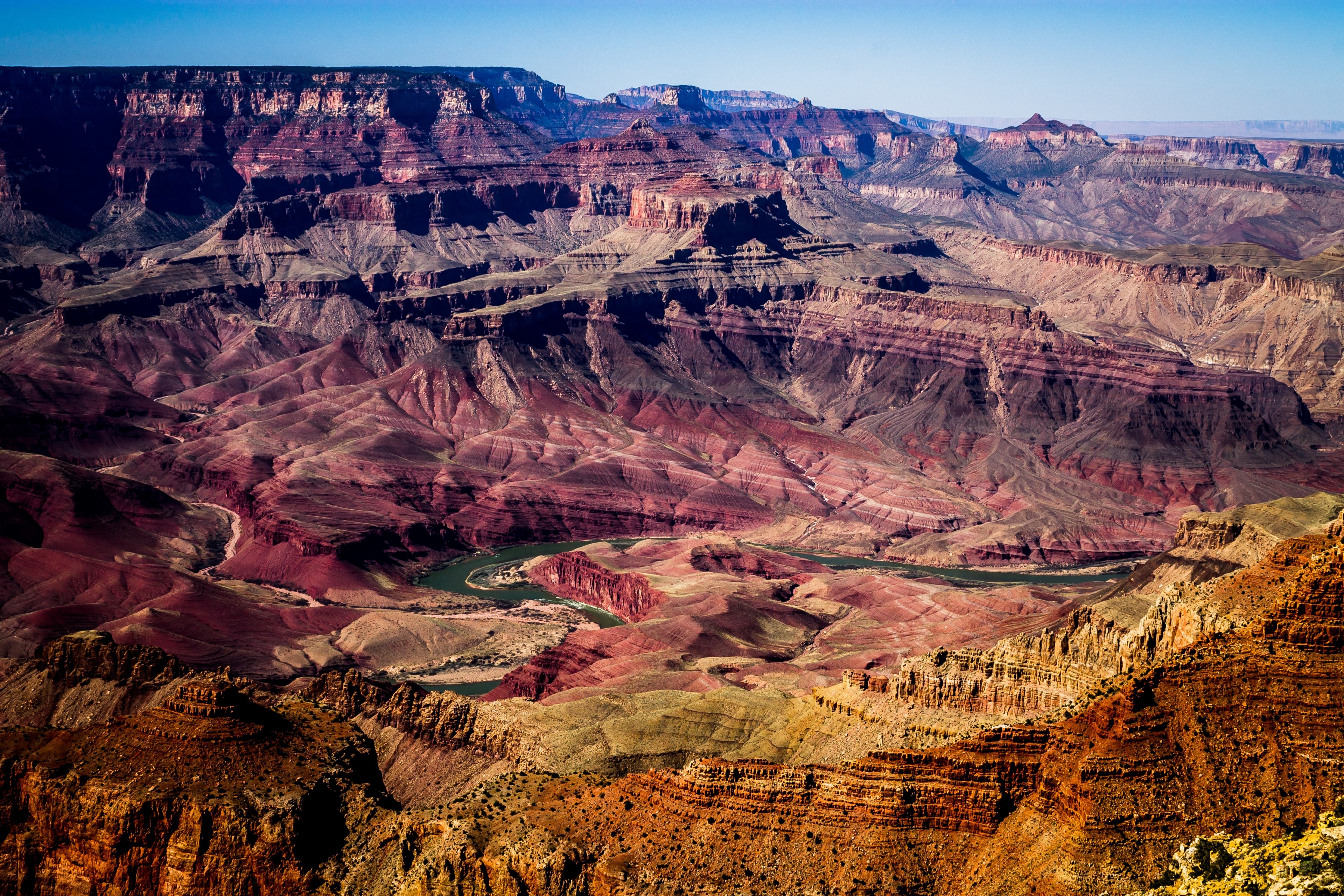Wallpaper / grand canyon aerial shot showing the ravine and layers of red and orange rocks, colorful grand canyon 4k wallpaper free download