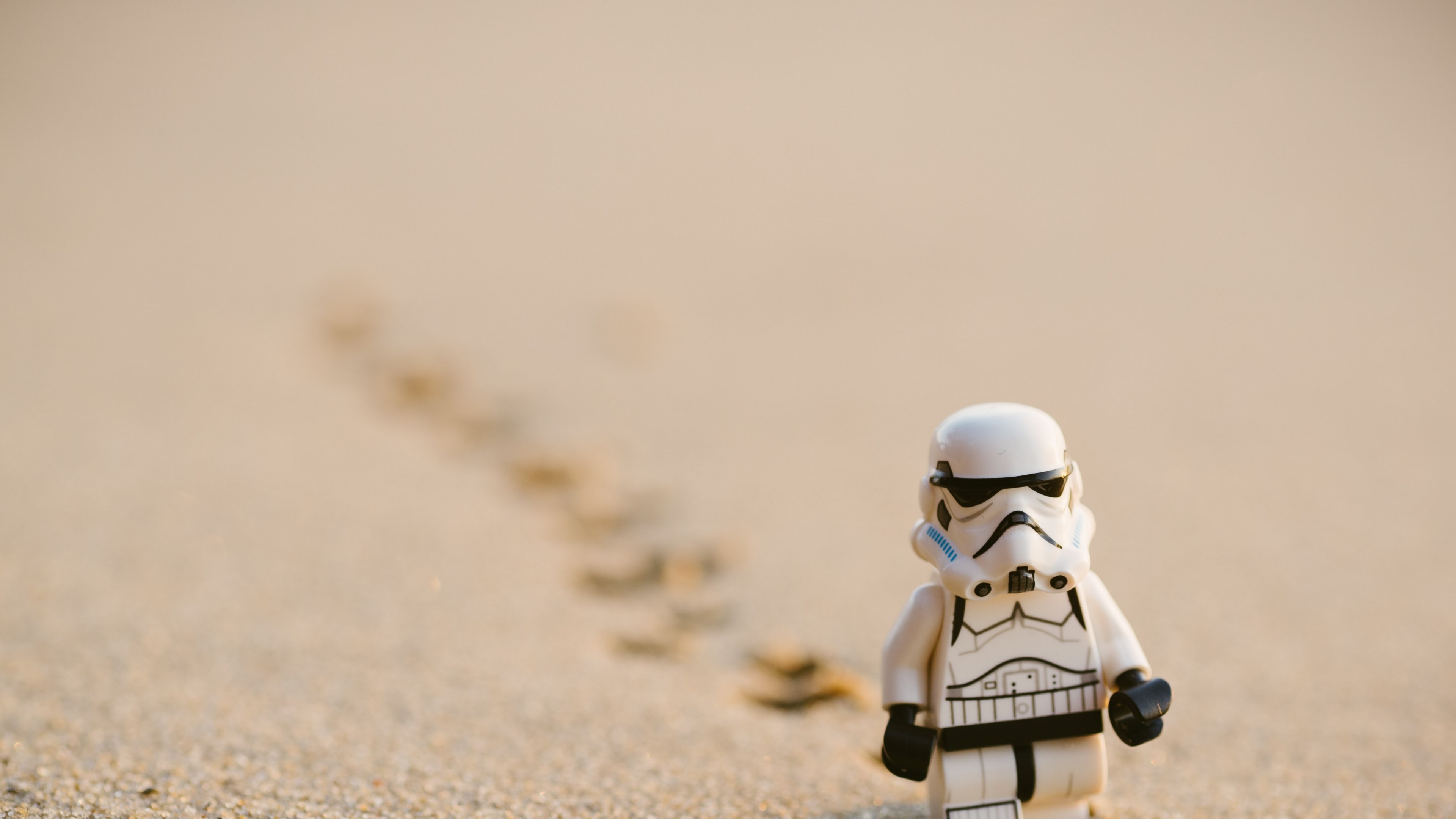 Wallpaper / a lego stormtrooper on sand, stormtrooper walking on sand 4k wallpaper free download