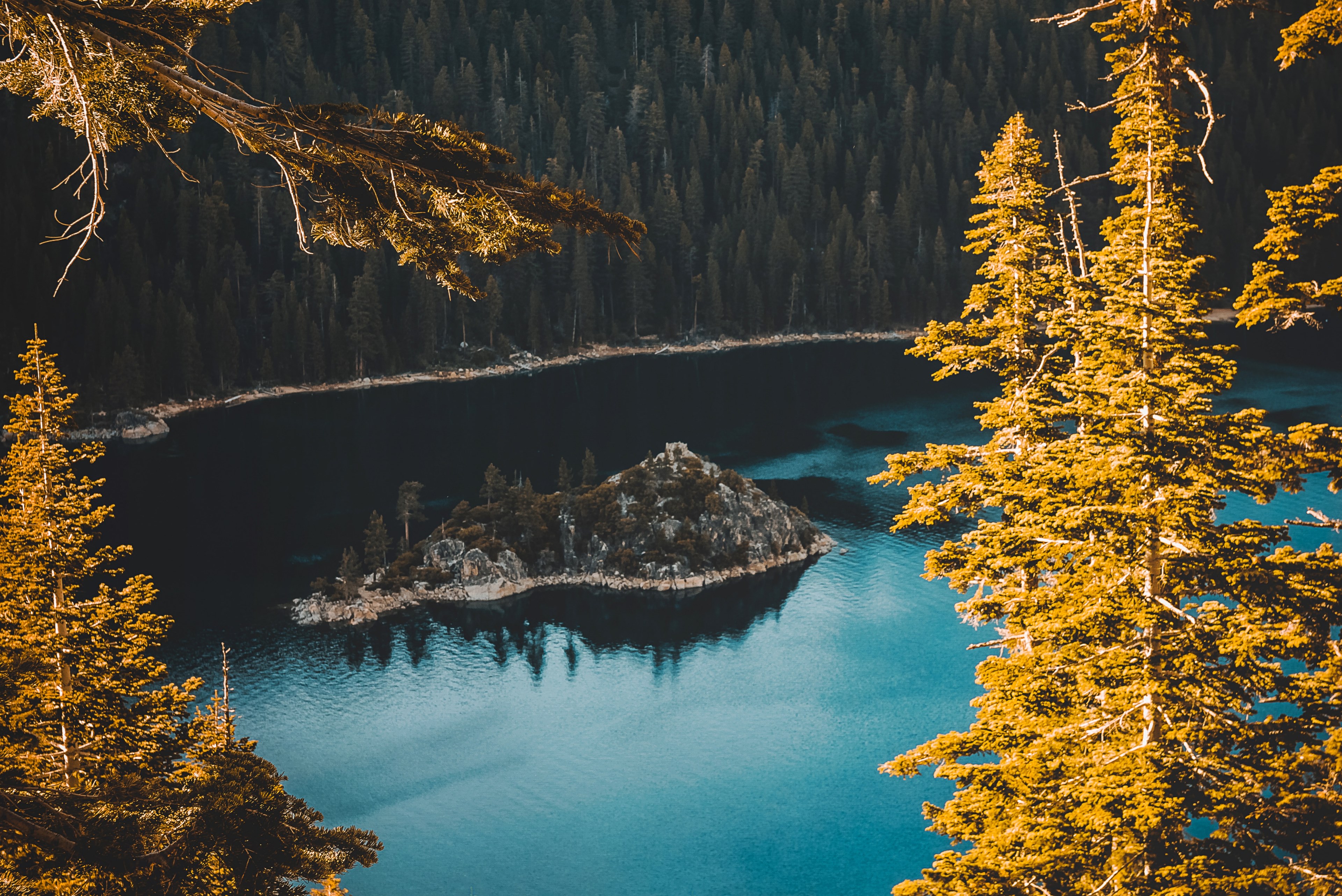 Wallpaper / a drone shot of an island in the middle of lake tahoe surrounded by the forest, lake island in the autumn 4k wallpaper free download