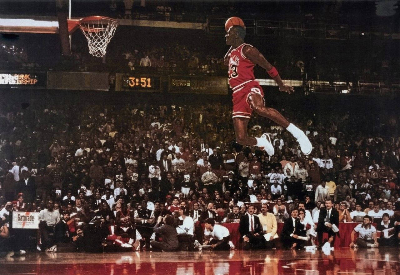 Download Michael Jordan reaches epic heights with a flying slam dunk Wallpaper