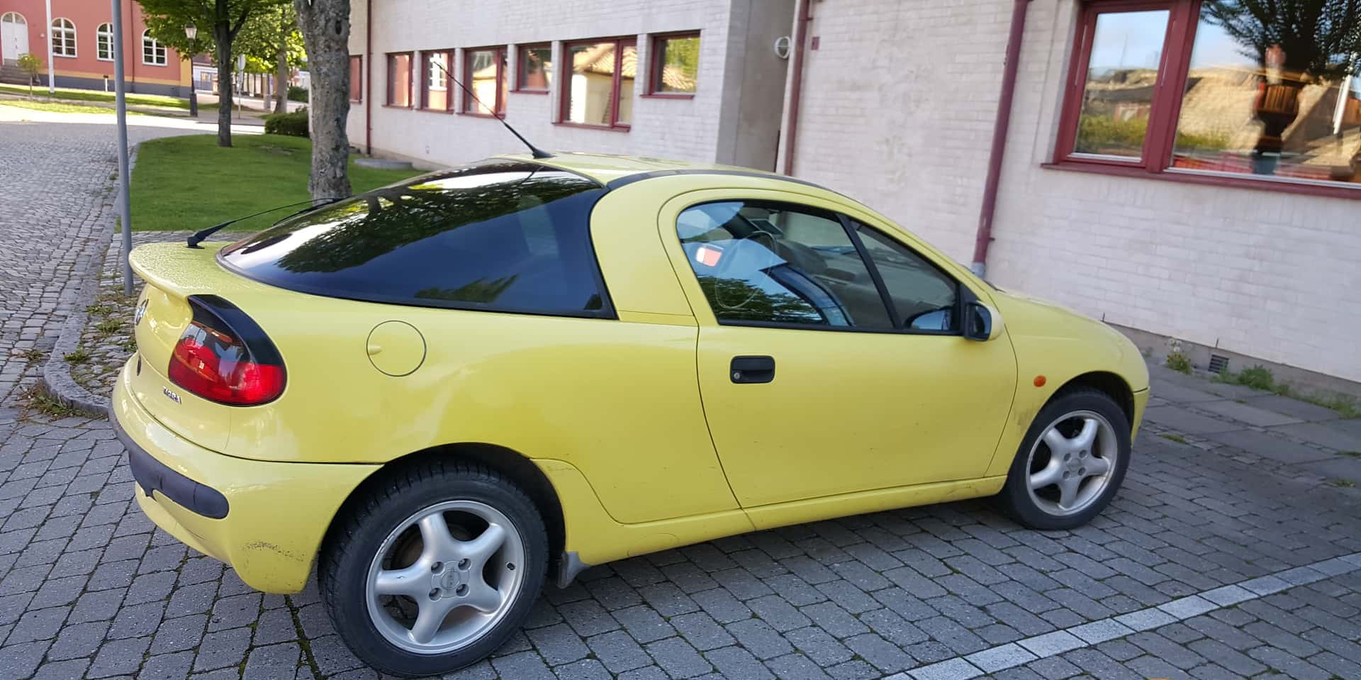Download Sleek And Stylish, The Opel Tigra On A Scenic Road Trip. Wallpaper
