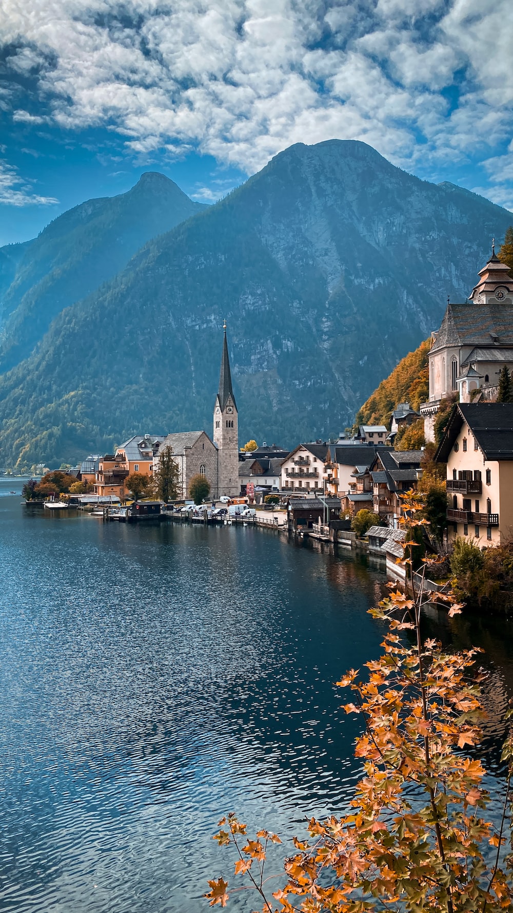A scenic view of a town on a lake with mountains in the background photo
