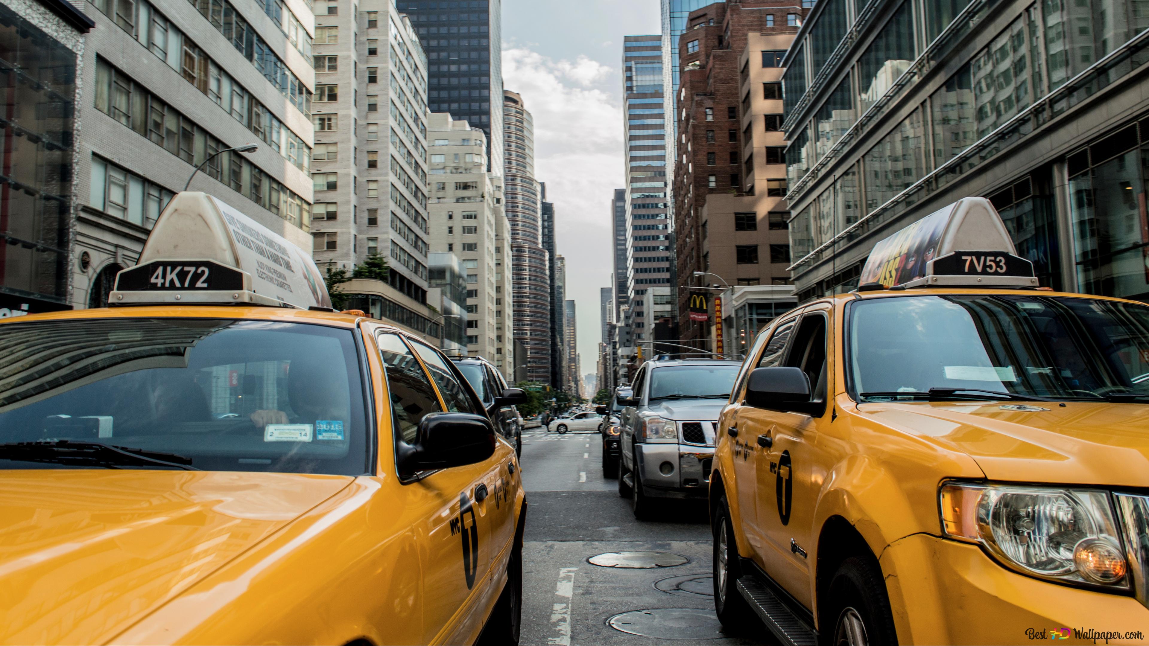 Yellow taxi caught on traffic in the city 4K wallpaper download