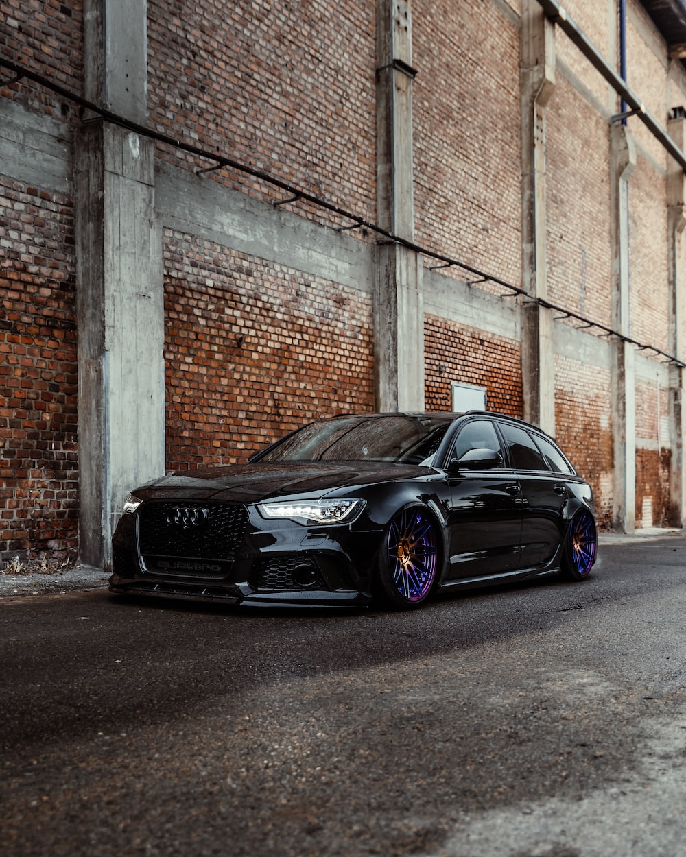 Black bmw m 3 coupe parked beside brown brick wall photo