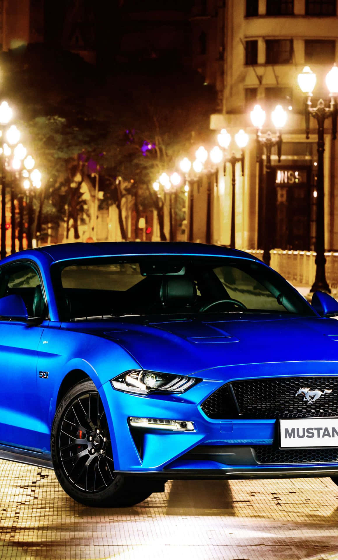 Download The Blue 2019 Ford Mustang Gt Is Parked On A City Street Wallpaper