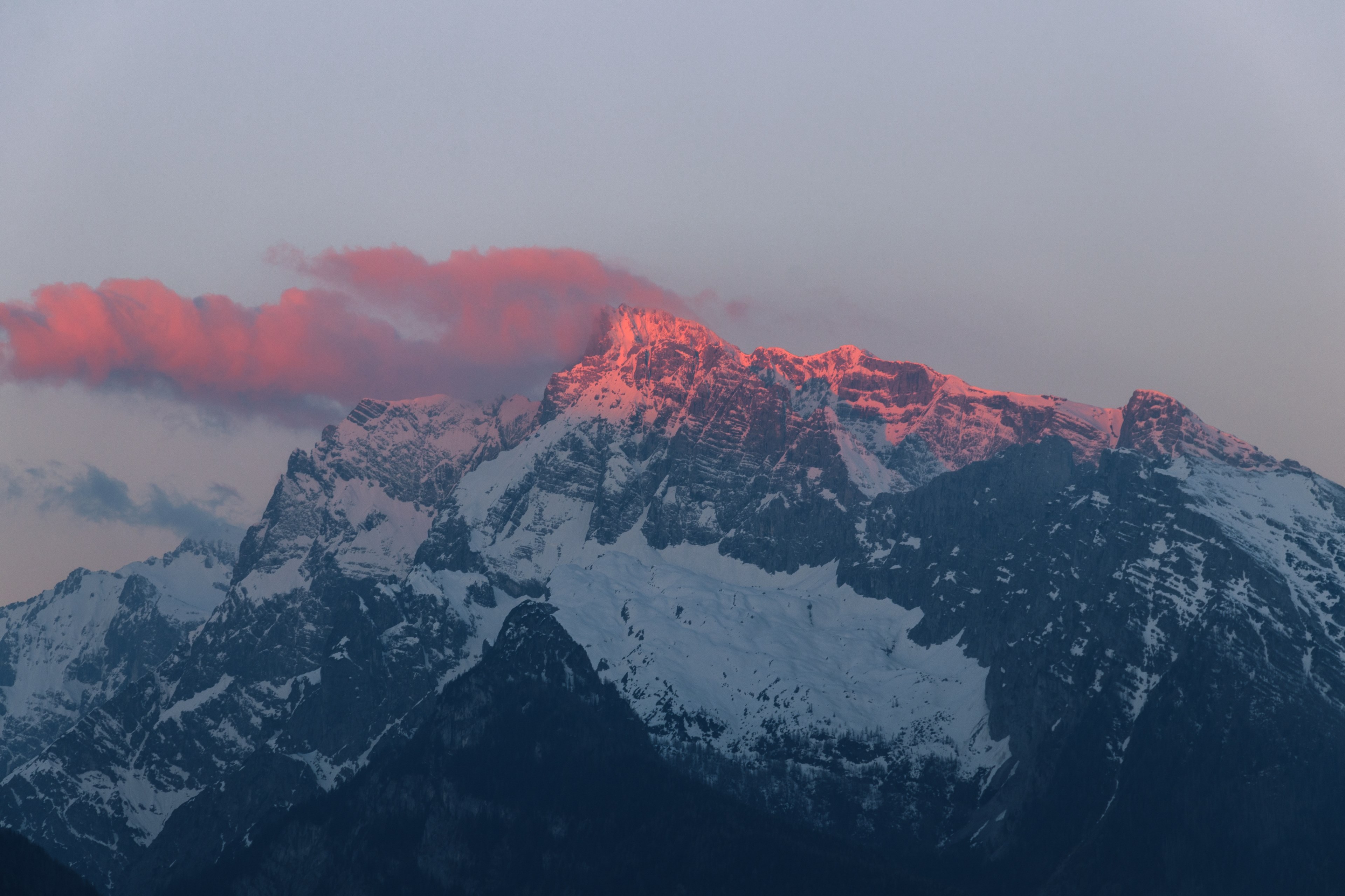 Wallpaper / red sunlight falls on the crest of a mountain during dusk, red sun rays on a white mountain 4k wallpaper free download
