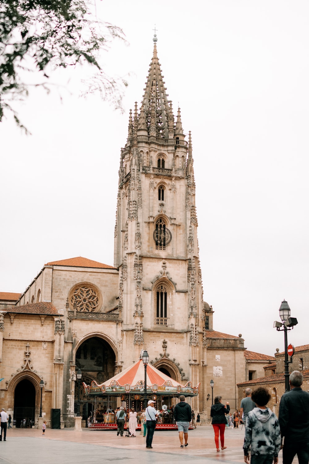 A large building with a clock tower with Oviedo in the background photo
