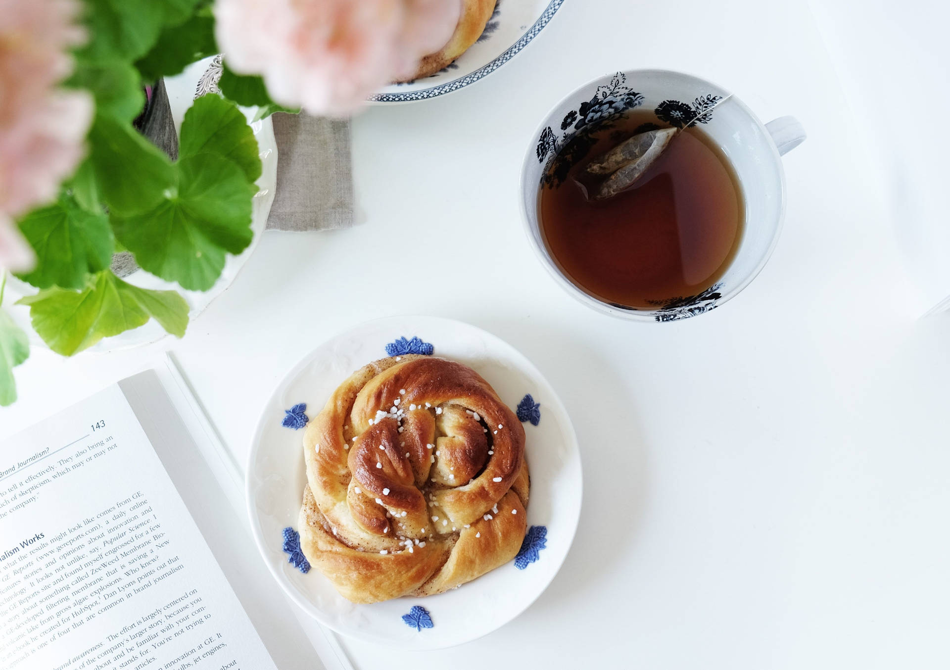 Download Delicious Cinnamon Bun Paired with Afternoon Tea Wallpaper