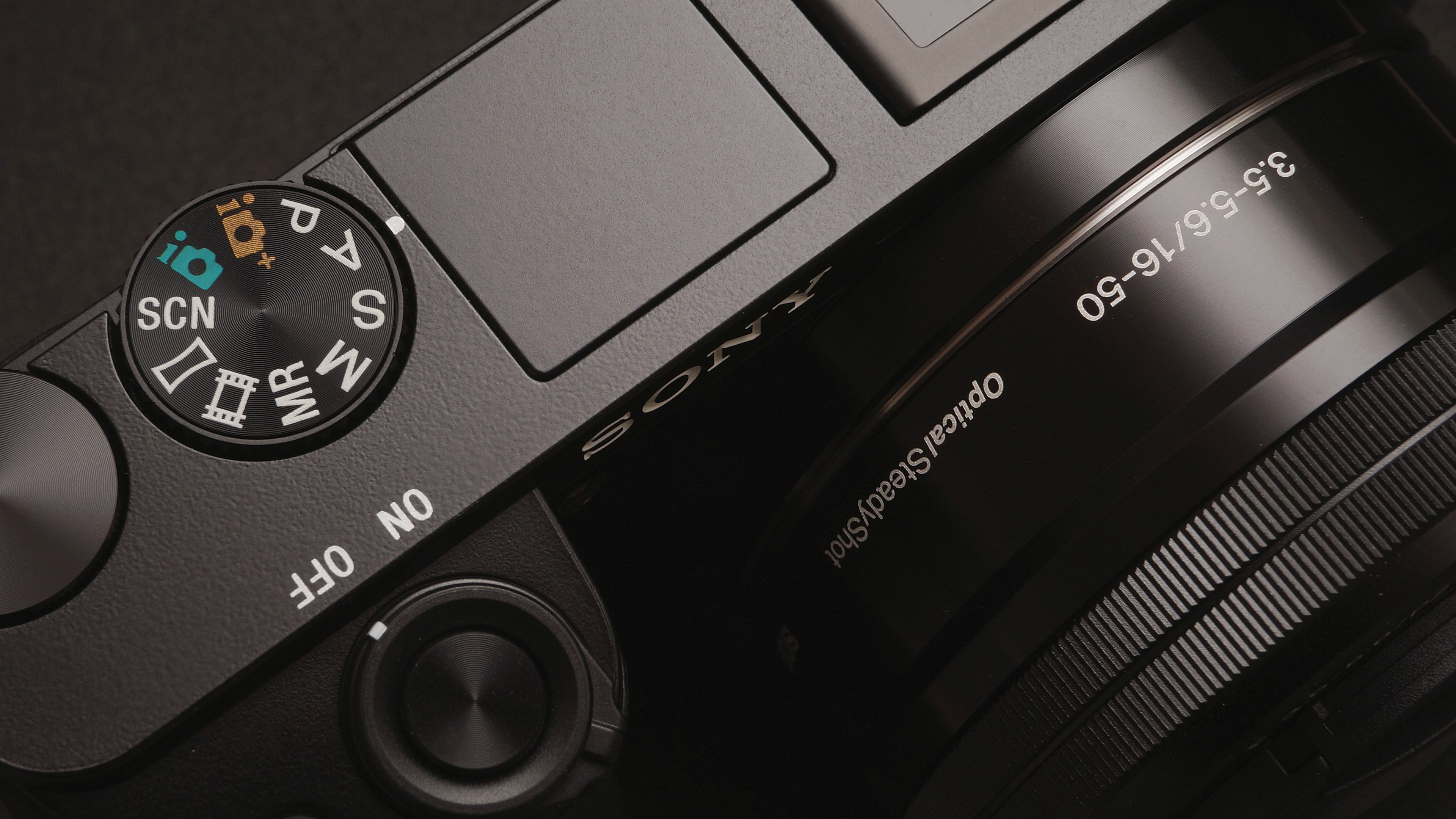 Wallpaper / macro of top of black sony camera with dial and on off switch, macro sony camera 4k wallpaper free download
