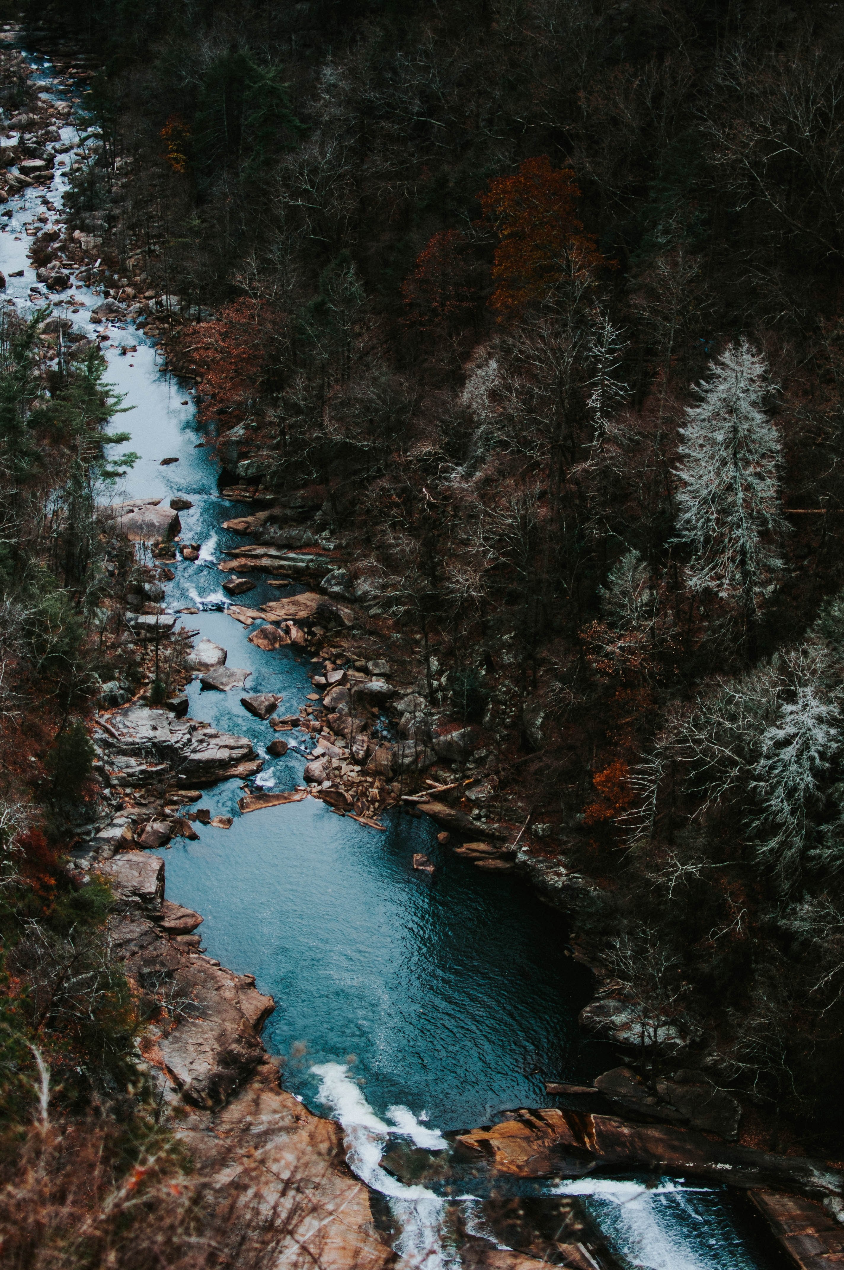 Wallpaper / a drone shot of an azure stream on a rocky bed in a colorful autumn forest, falls 4k wallpaper free download