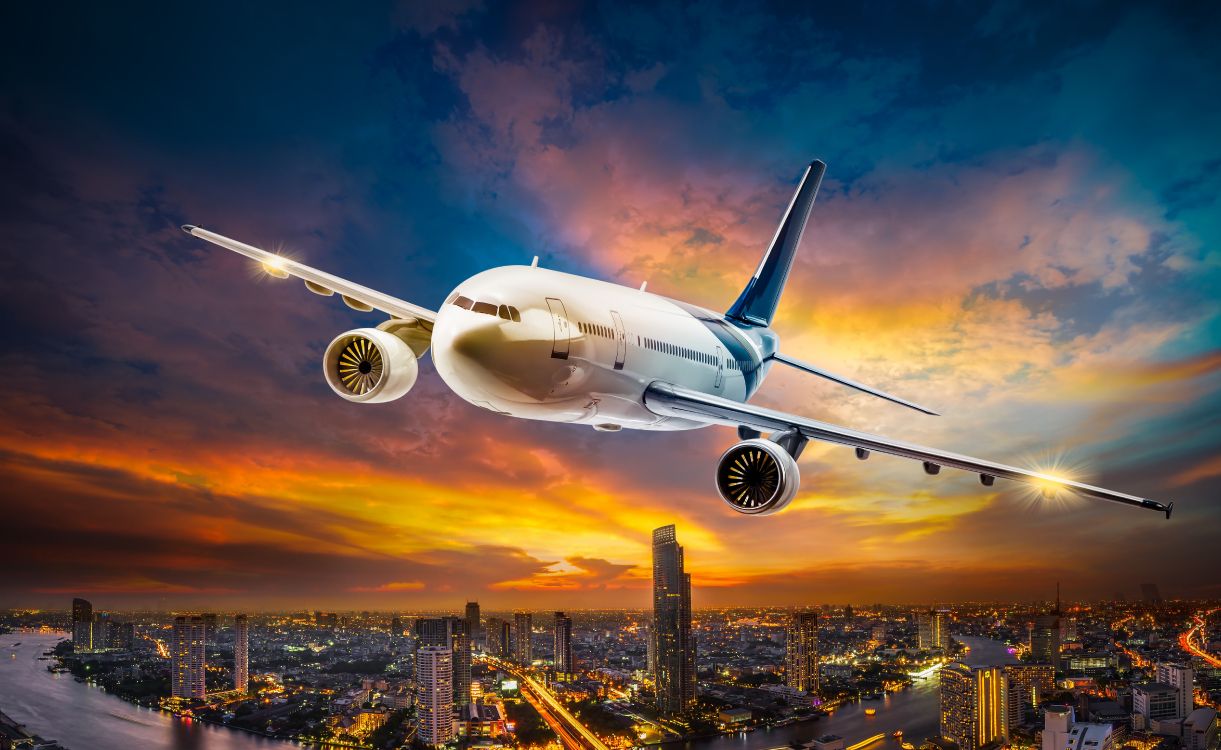 Wallpaper White Passenger Plane Flying Over City Buildings During Daytime, Background Free Image