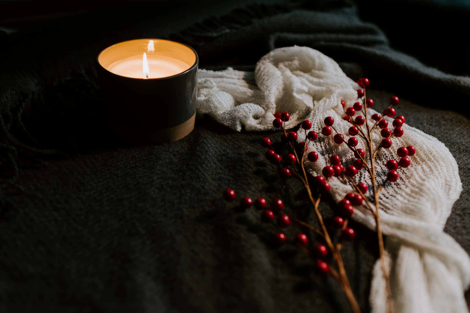Download A Candle And Berries On A Bed Wallpaper