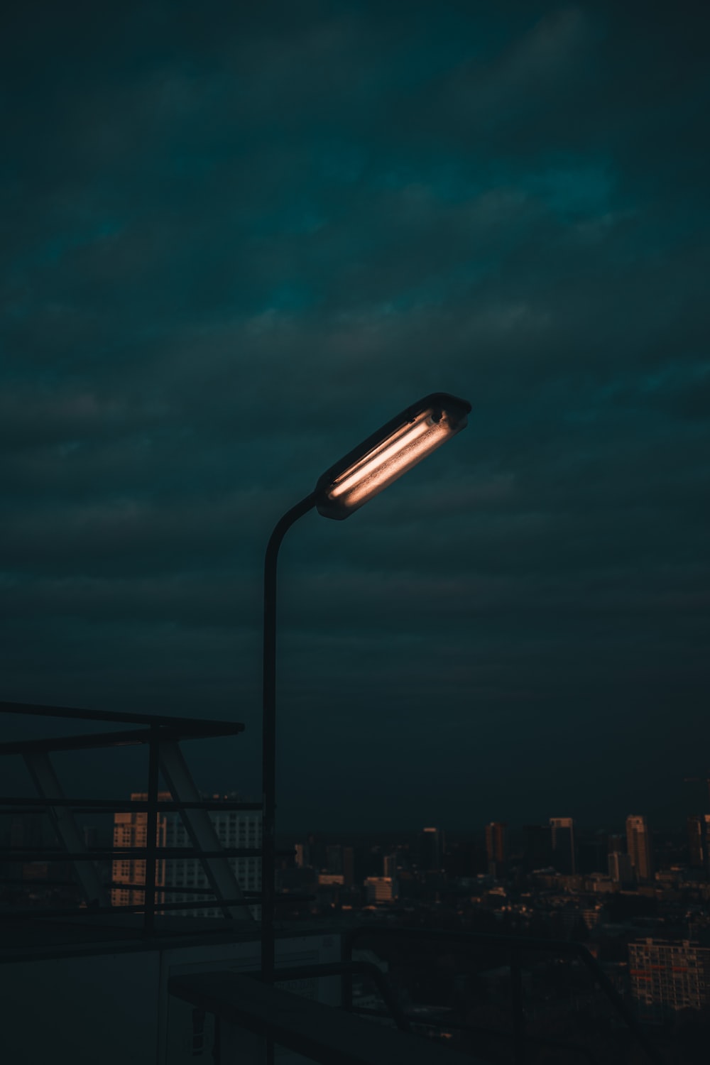 A street light in the dark with a city in the background photo