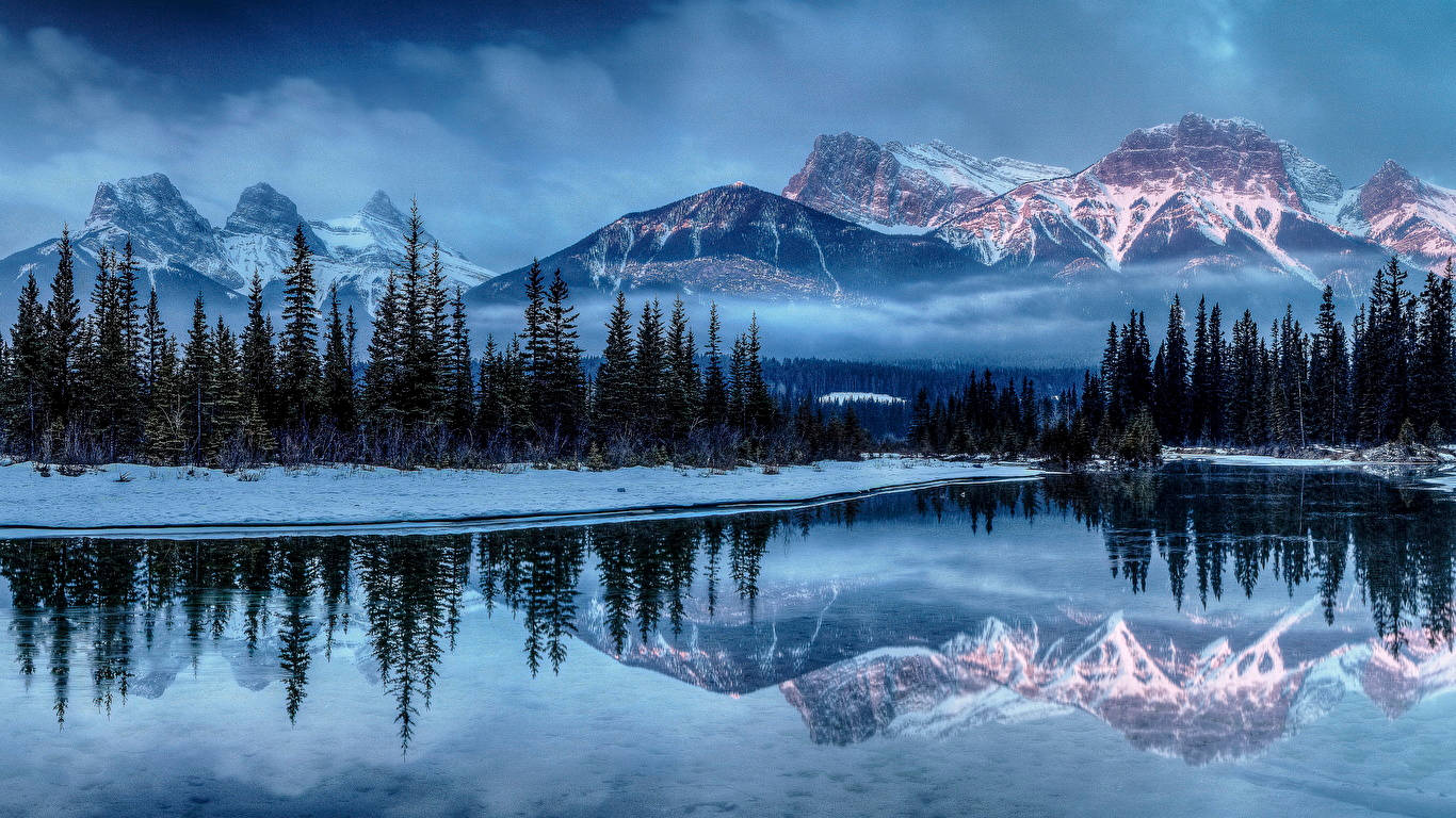 Download 1366 X 768 Winter Lake By Forest And Mountain Wallpaper