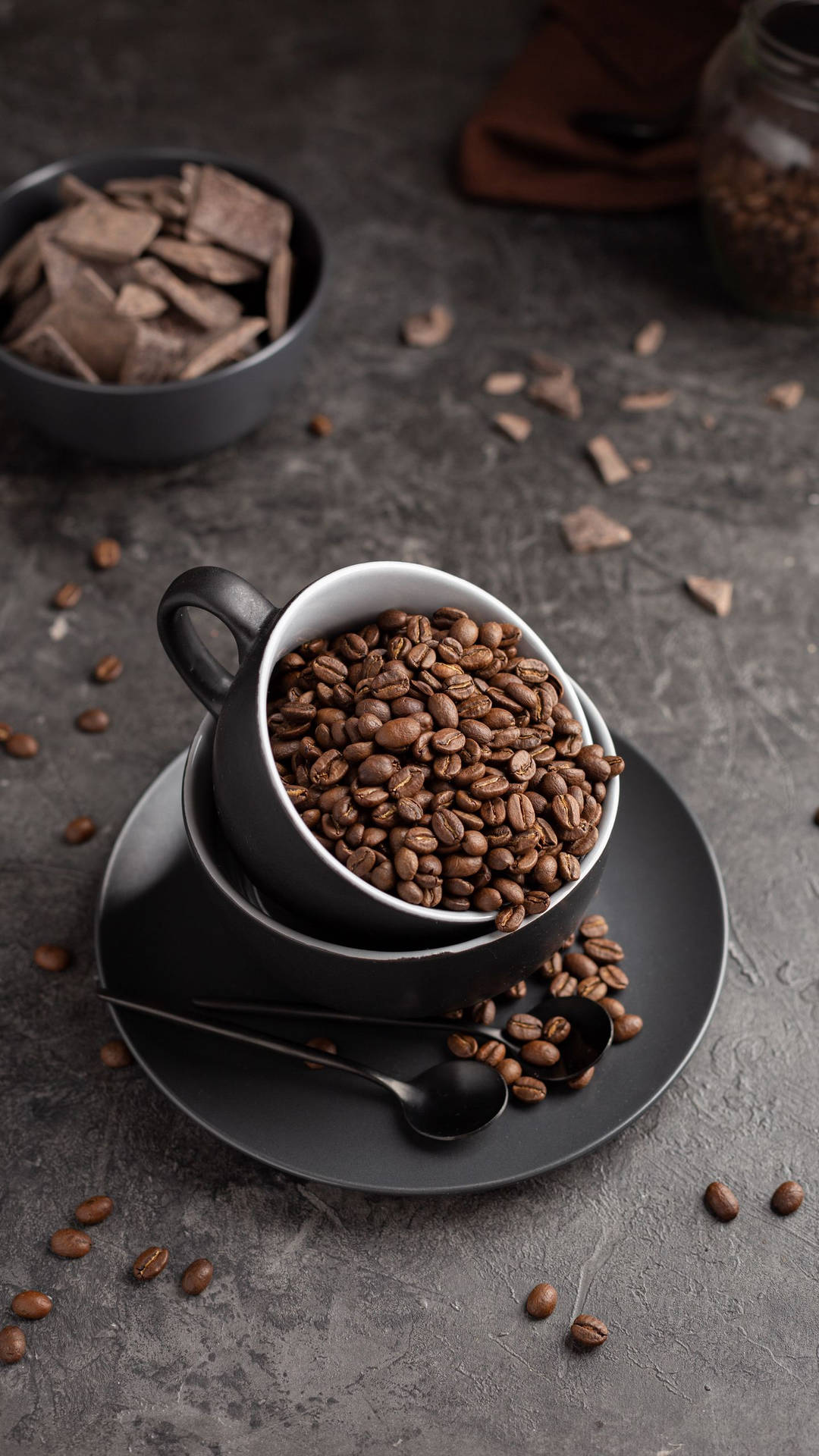 Download Sleek Black Cup Full Of Coffee Beans Wallpaper