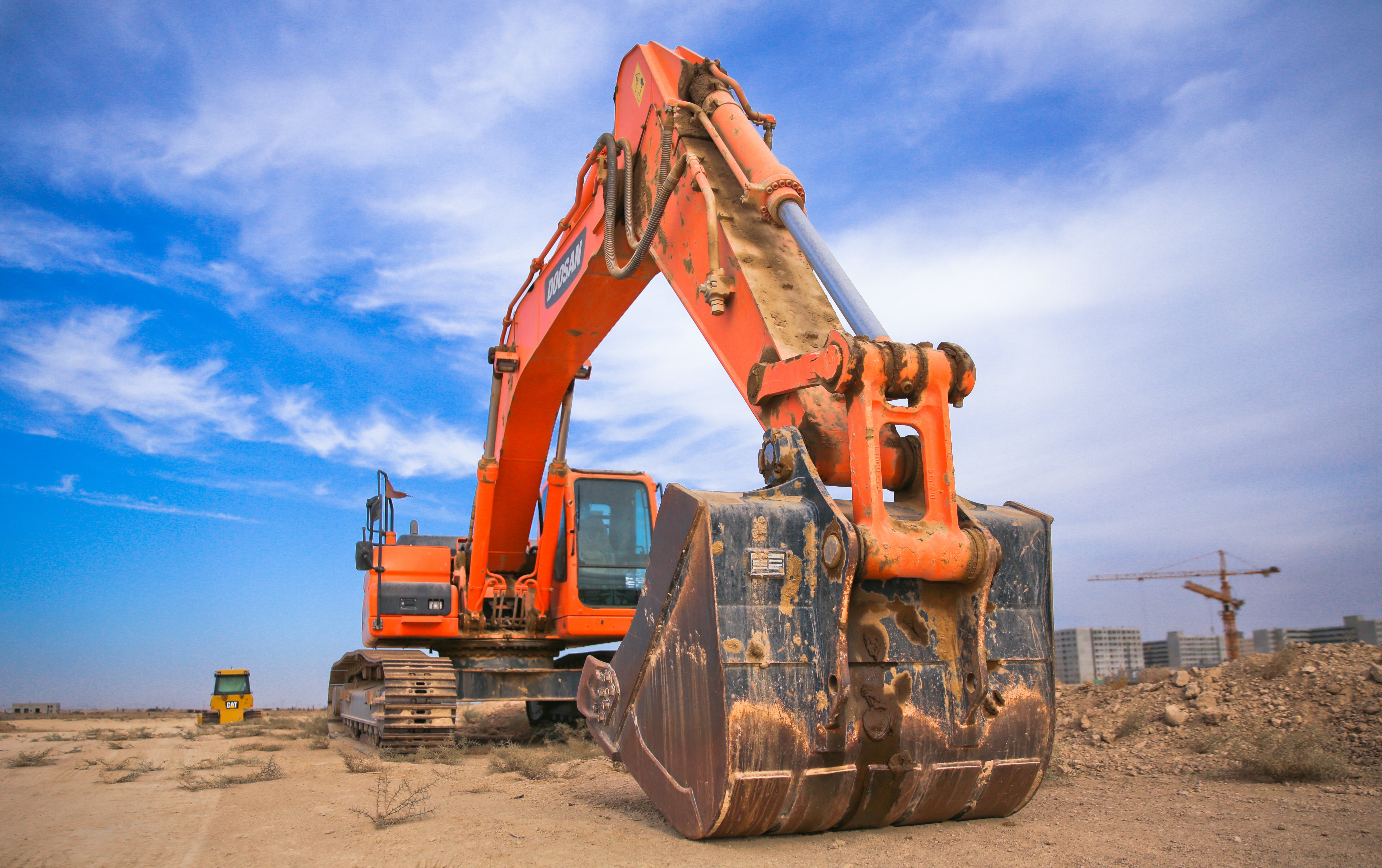 Low Angle Photography of Orange Excavator Under White Clouds · Free