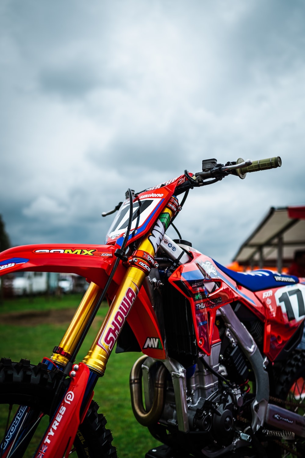 A red dirt bike parked on top of a lush green field photo