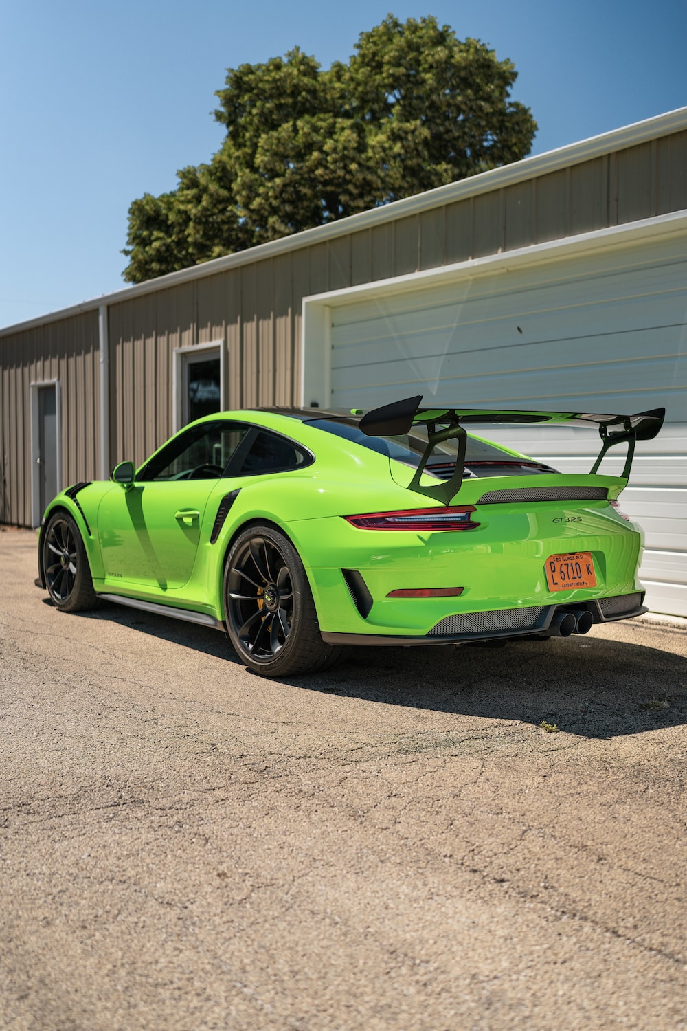 Green porsche 911 parked near white building photo