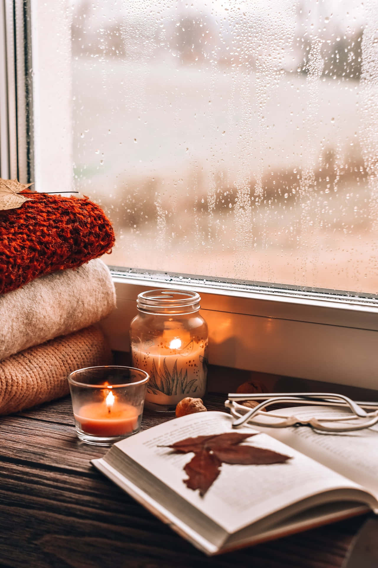 Download A Window With Candles, A Book, And A Blanket Wallpaper