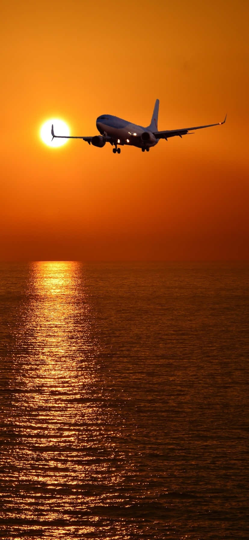 Download A Plane Flying Over The Ocean Wallpaper
