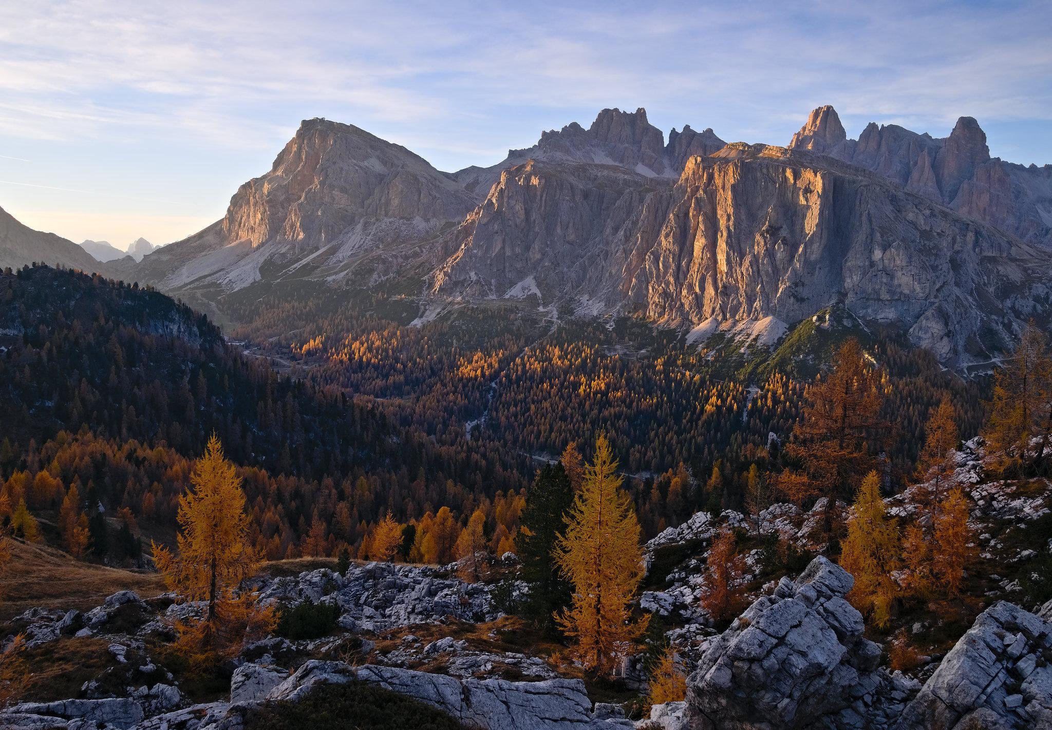 Glowing larches and massive rock faces in the Dolomites [OC][2048x1423]