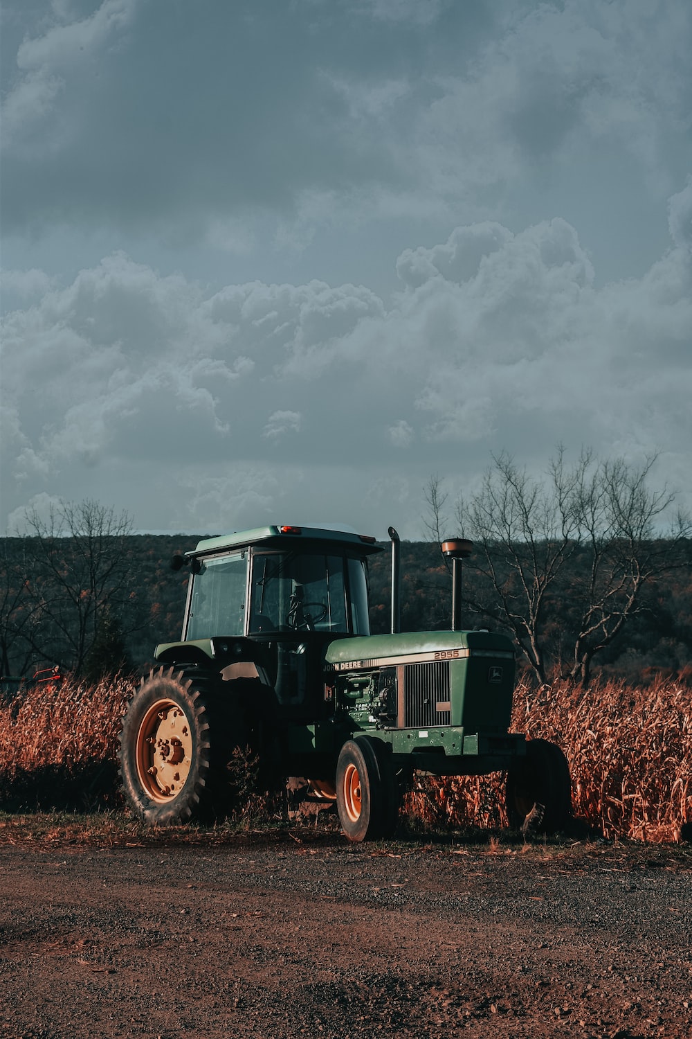 A green tractor is parked in a field photo